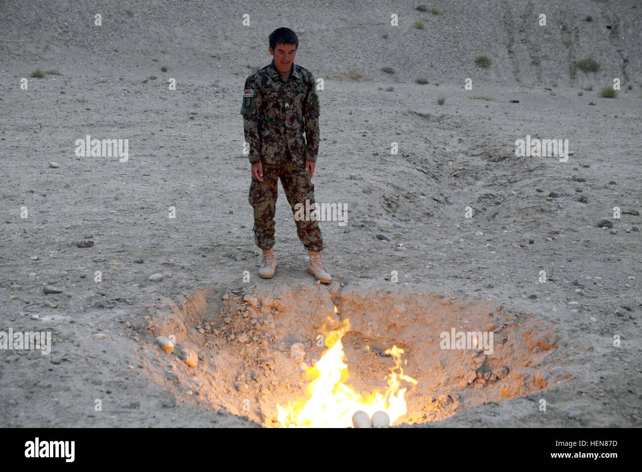 An Afghan National Army soldier oversees the burning of unexploded secondary high explosives during a training exercise at the demolition range on Forward Operating Base Gamberi, Laghman province, Nov. 5, 2013. The demolition range is the site for an Explosive Hazard Reduction Course for soldiers with the ANA. (U.S. Army photo by Spc. Ryan D. Green/Released) ANA Explosive Hazard Reduction Course 131105-A-YW808-145 Stock Photo