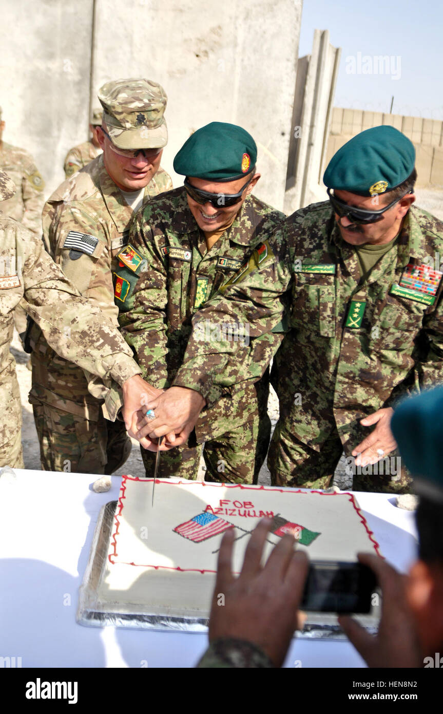 U.S. Army Lt. Col. Eric Smith (left), commander of 3rd Squadron, Combined Task Force Dragoon, Afghanistan National Army Lt. Col. Babakhan Hassani (middle), commander of 4th Kandak and Col. Said Zainuddin Rohani (right), commander of 6th Kandak, both with 3rd Brigade, 205th Corps, cut a cake together after a transfer ceremony Nov. 15, 2013, at Forward Operating Base Azizullah, Afghanistan. Troops with 3rd Squadron relinquished authority over the base to the ANA and Afghan National Civil Order Police in support of Operation Enduring Freedom. (U.S. Army Photo by Spc. Joshua Edwards) Cake cutting  Stock Photo