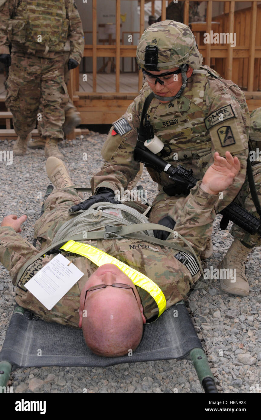 Azusa, Calif. native, Sgt. Angalique Reedy (right), a combat medic, 82nd Sustainment Brigade-U.S. Central Command Materiel Recovery Element, gives medical care to St. Louis native, Staff Sgt. Christopher Hahn, an 82nd SB-CMRE brigade victim's advocate, who has a simulated abdominal wound during a Nov. 22 mass casualty exercise at Kandahar Airfield, Afghanistan. (U.S. Army photo by Sgt. 1st Class Jon Cupp, 82nd SB-CMRE Public Affairs) 82nd SB-CMRE conducts mass casualty exercise in Afghanistan 131122-A-MU632-947 Stock Photo