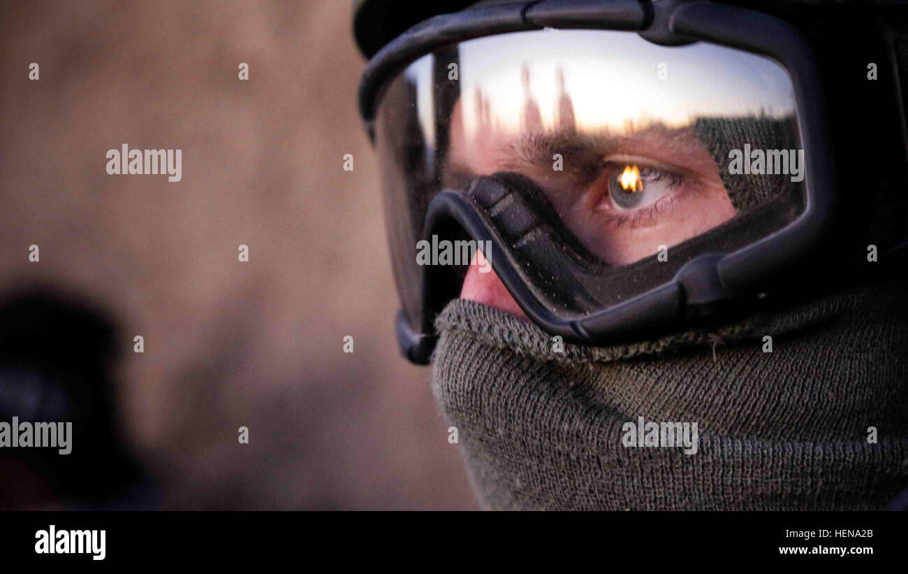 A U.S. Special Forces soldier with the combined Joint Special Operations Task Force-Afghanistan, watches as Afghan National Security Forces stand by a fire for warmth after a clearing operation in Shah Joy district, Zabul province, Afghanistan, Dec. 28, 2013. During the operation, two suspects were detained, and several improvised explosive devices precursor materials were destroyed. (U.S. Army photo by Pfc. David Devich/ Released) Afghan National Security Forces conduct operations in Shah Joy district 131228-A-XP365-149 Stock Photo