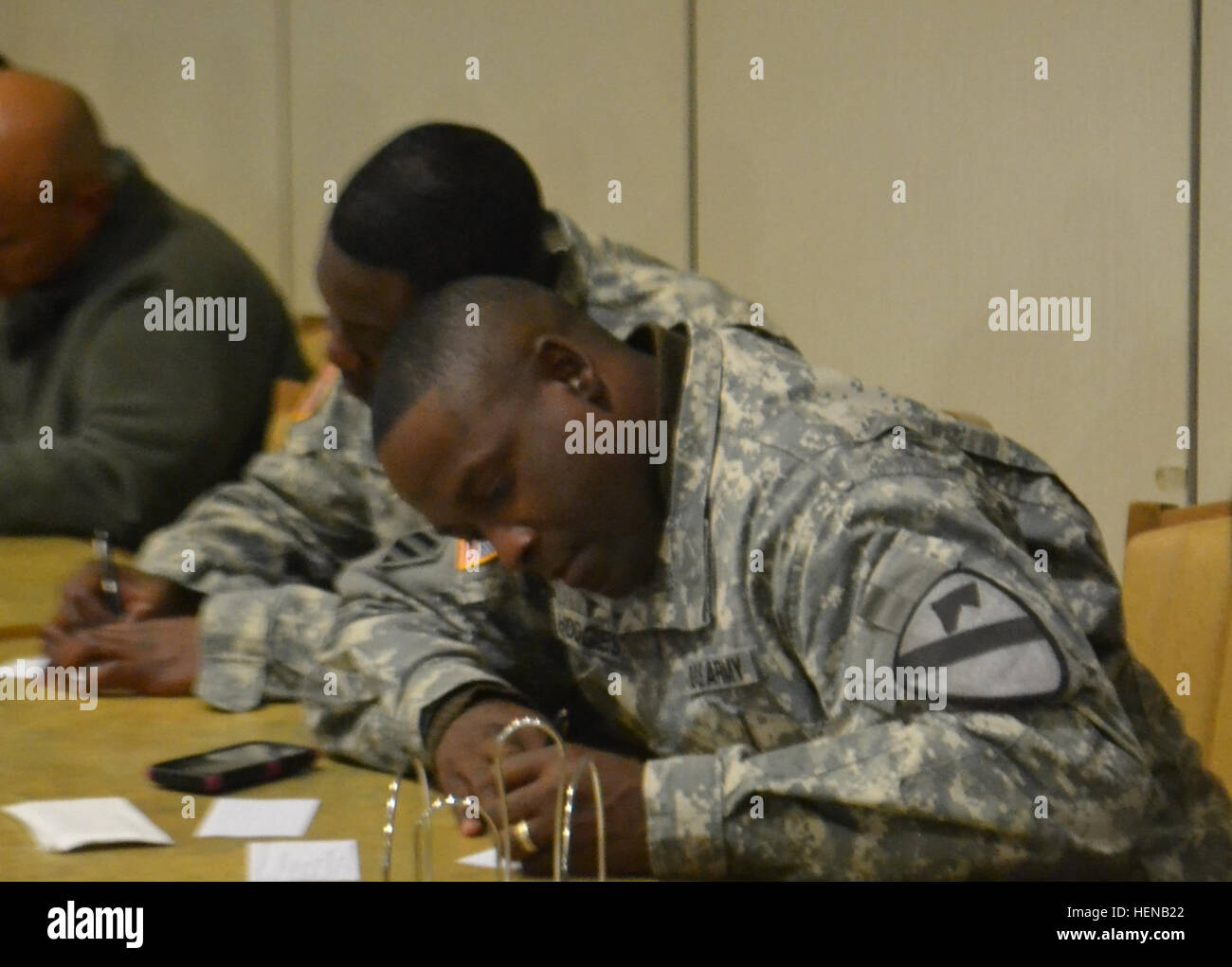 Staff Sgt. Jameel Hodges, a transportation platoon sergeant for Alpha Distribution Company 125th Brigade Support Battalion, 3rd Brigade Combat Team, 1st Cavalry Division, takes notes at the noncommissioned officer development program Jan. 29, at the Operation Iraqi Freedom Dining Facility on Fort Hood, Texas (U.S. Army photographed by Spc. Genesia Zanardi HHC, 215th BSB UPAR, 3rd BCT, 1st Cav. Div.) Blacksmiths enforcing and executing 140129-A-XX000-003 Stock Photo