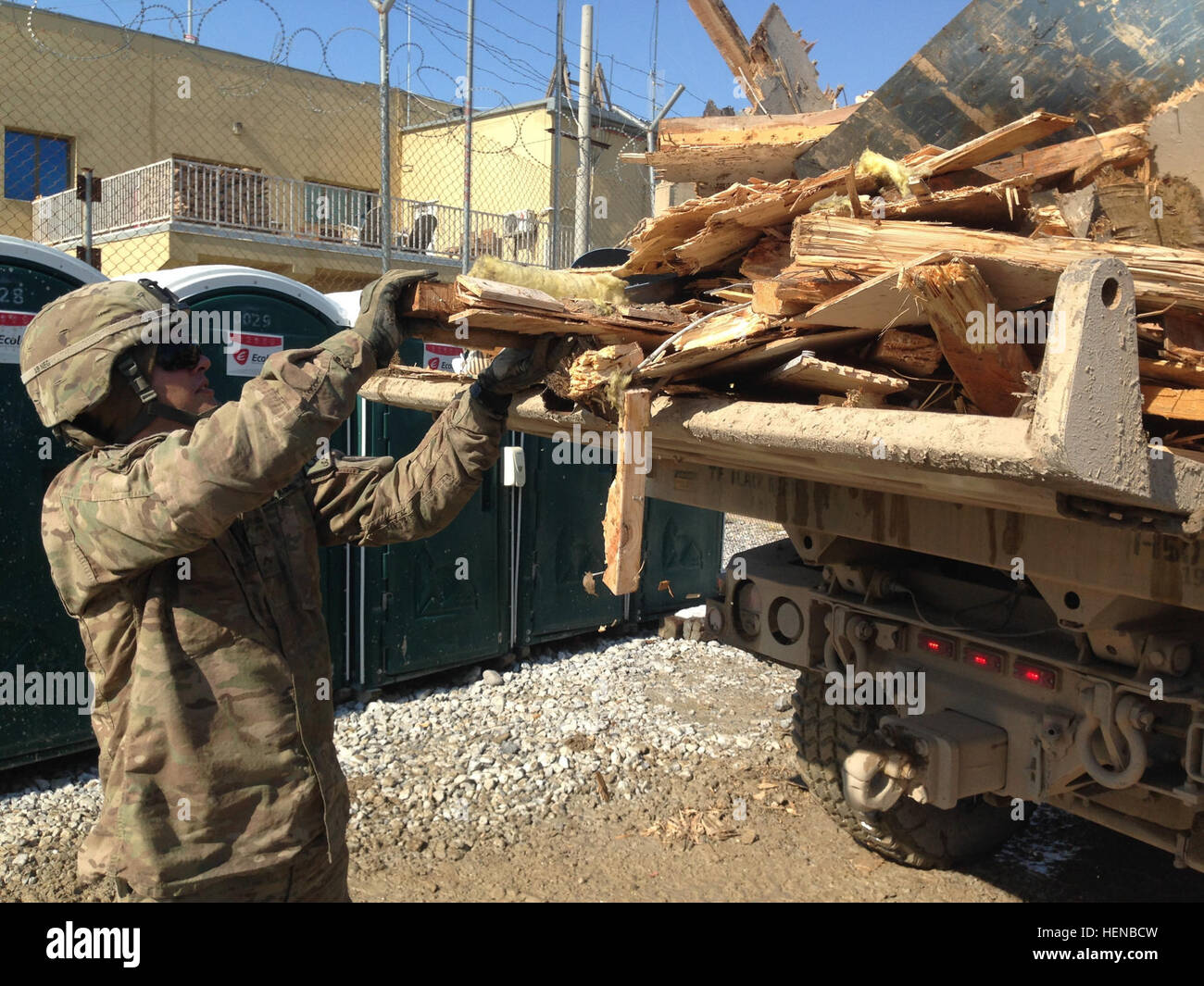 Newly promoted Pfc. Robert Barnard, a native of South Plainfield, N.J., and a horizontal construction engineer for the Hammonton, N.J.-based 150th Engineer Company, attached to the 133rd Engineer Battalion, loads debris from a torn-down job site onto a 10-ton dump truck Feb. 8 at Bagram Air Field, Afghanistan. (U.S. Army photo by Spc. Makanjuola Abimbola, 150th Engineer Company UPAR) 133rd Engineer Battalion keeps projects going on BAF 140208-A-ZZ999-721 Stock Photo