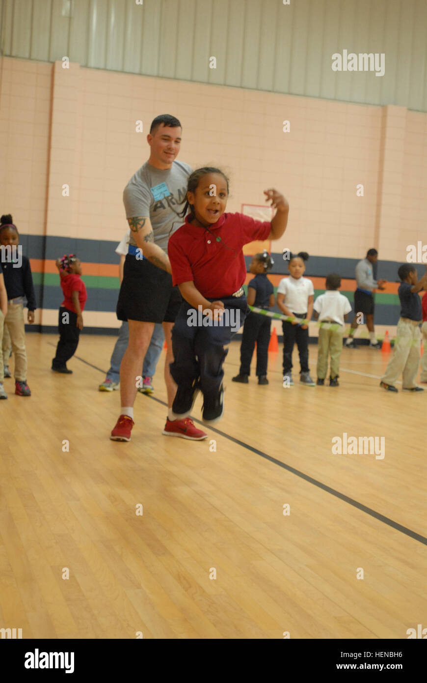 Spc. John Heard, an indirect fire infantryman with Headquarters and Headquarters Troop, 6th Squadron, 8th Cavalry Regiment, 4th Infantry Brigade Combat Team, 3rd Infantry Division, turns the jump rope for a Lyman Hall Elementary School student at an event celebrating the end of the school's "Jump Rope for Heart" fundraiser, Feb. 13, 2014, in Hinesville, Ga. The event helped to raise funds for the American Heart Association. 6-8 CAV joins community to Jump Rope for Heart 140213-A-ZG315-002 Stock Photo