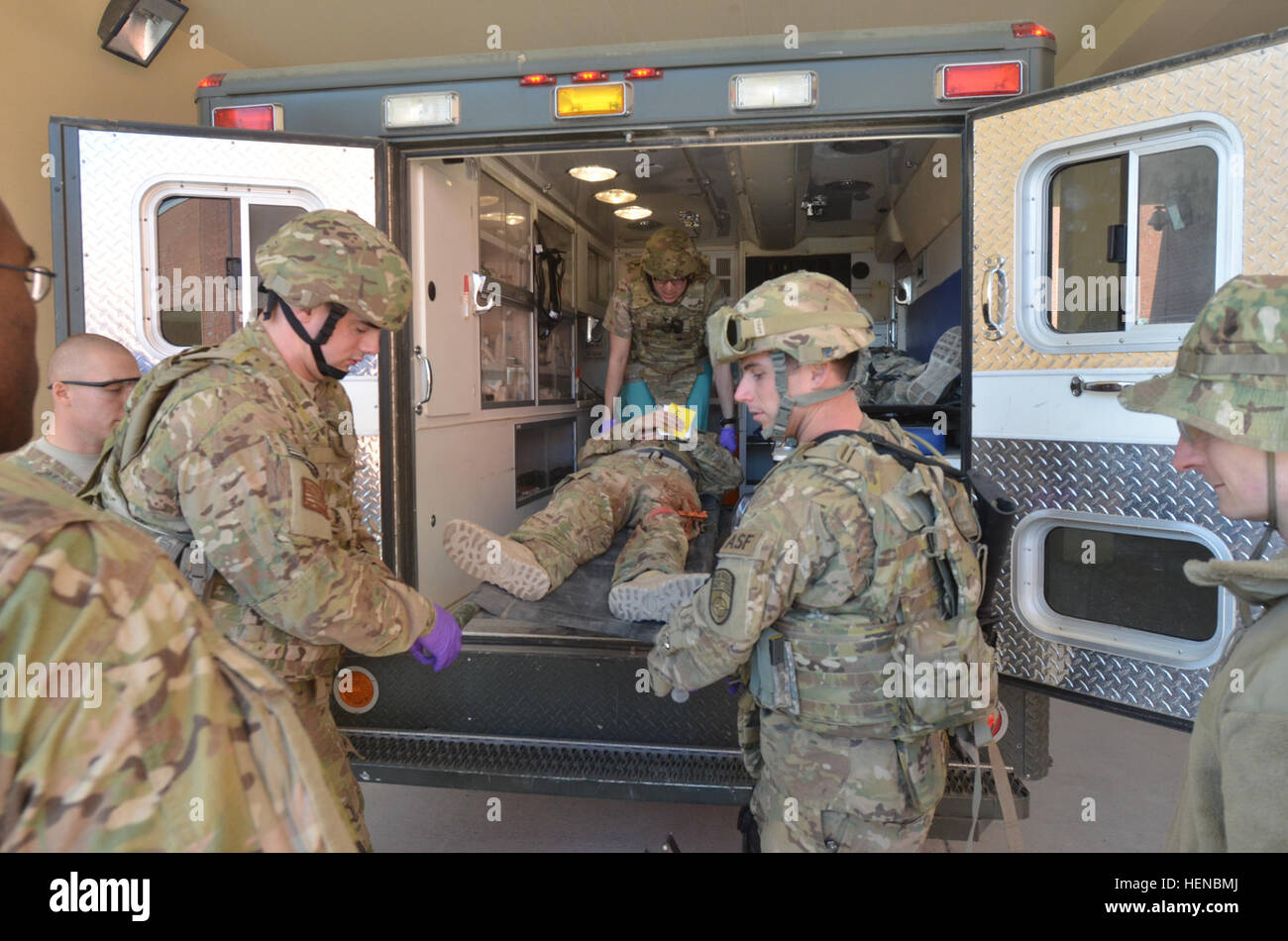 Soldiers assist Kandahar Airfield Role 3 Hospital providers with unloading 'injured' patients from an ambulance during a mass casualty exercise Feb. 14, 2014. The exercise involved responding to injured personnel from a civilian helicopter crash and the triage and movement of the injured to higher levels of care. (U.S. Army photo by Capt. Andrew Cochran/released) More coming in 140214-A-VT601-402 Stock Photo