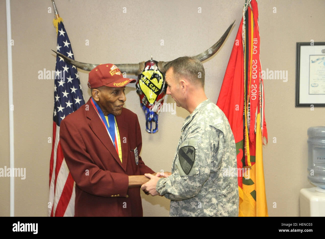 Col. Cory Mendenhall (right), a Bonners Ferry, Idaho, native, and commander of the 1st Air Cavalry Brigade, 1st Cavalry Division, presents a coin to retired Lt. Col. Granville Coggs at Hood Army Airfield, Fort Hood, Texas, Feb. 21. Coggs, one of an estimated 50 remaining Tuskegee Airmen - the first all African-American pursuit squadron based in Tuskegee, Ala., in 1941 - was a guest speaker during the III Corps and 1st Air Cav. Brigade's equal opportunity offices' 'Strength through Equality' Black History Month observance. III Corps, 1st Air Cav hold Black History Month observance 140221-A-WD32 Stock Photo