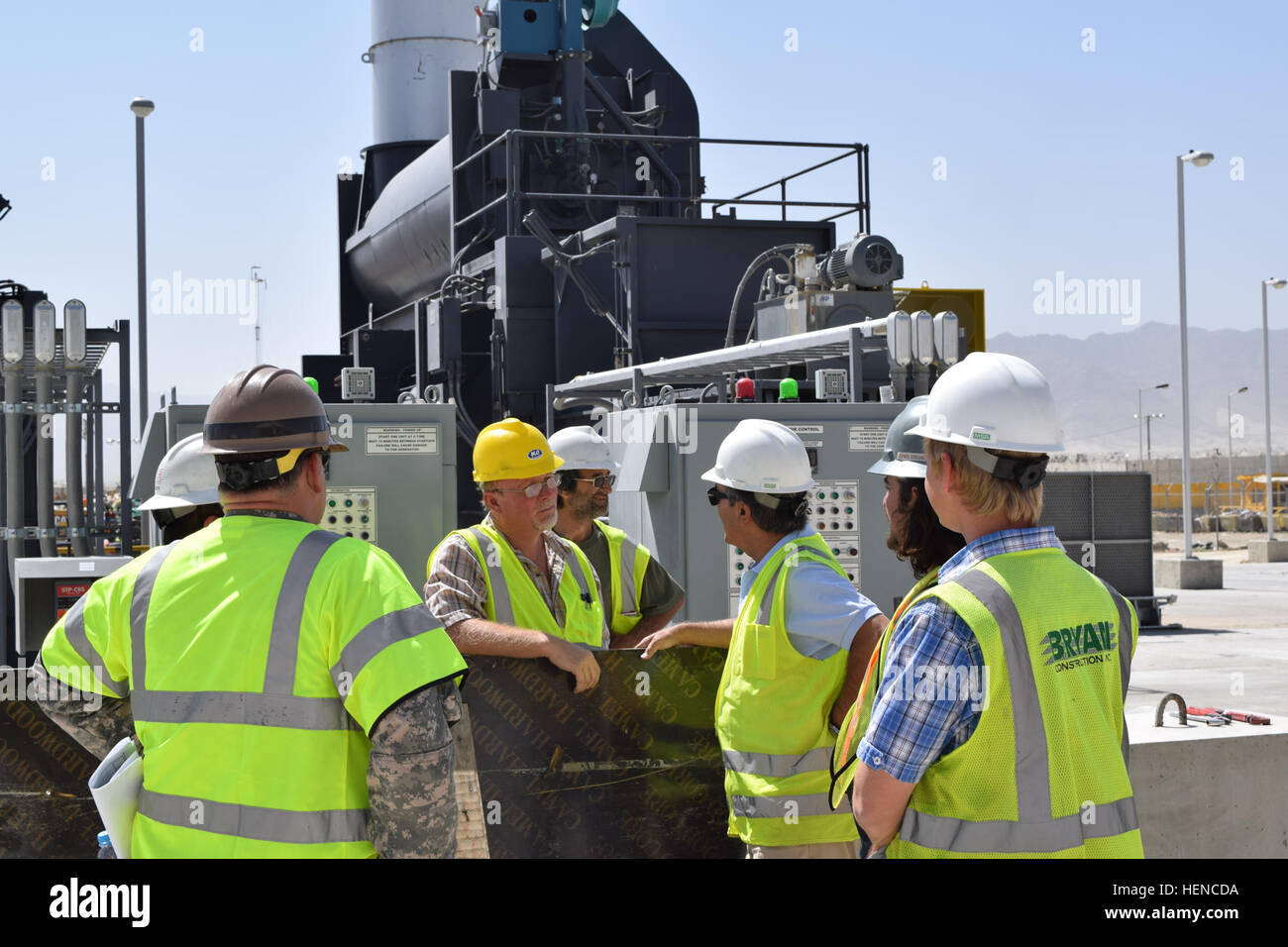 Mr. Christopher Miranda, project manager for the U.S. Army Corps of Engineers, speaks with construction company personnel in front of a new trash incinerator at the new Waste Management Complex on Bagram Air Field, Afghanistan, July 16, 2014. This incinerator is one of six at the facility. (DoD photo by U.S. Army Maj. Devon McRainey/Released) New Waste Management Complex at Bagram Air Field 140716-A-XY287-002 Stock Photo