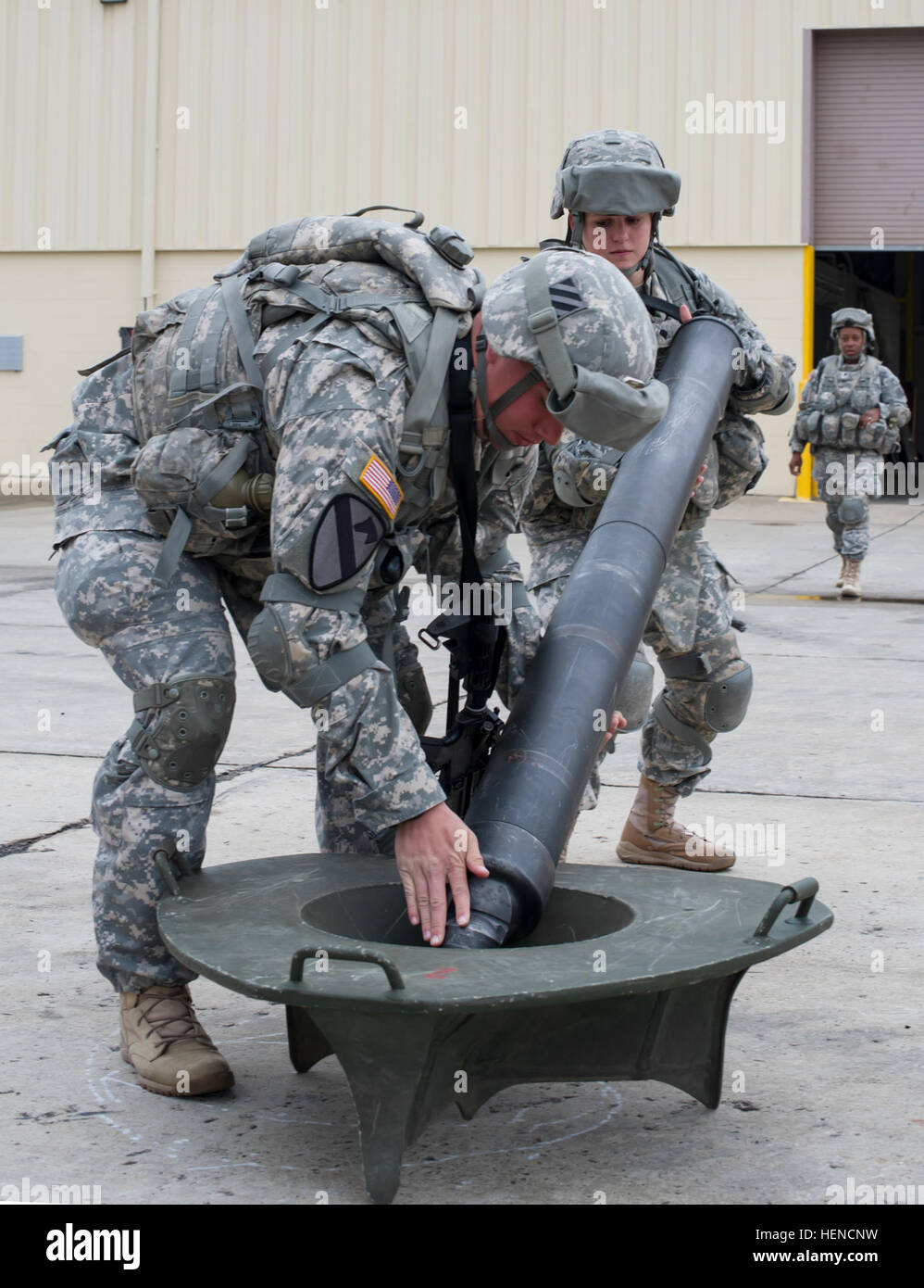 Spc. Koty Roby (left) and Spc. Rachel Wickline (right), both assigned to the Physical Demands Study, Mortarman Platoon, Company D “Dragons,” 1st Battalion, 30th Infantry Regiment “Battle Boars,” 2nd Armored Brigade Combat Team, 3rd Infantry Division, quickly place a mortar tube on a base plate after running the base plate and then the tube 16.5 yards here at the Battle Boars’ motor pool, March 12. This task is just one part of the PDS that the Dragons have been spearheading for the 2nd ABCT, in conjunction with U.S. Army Training and Doctrine Command, and the U.S. Army Research Institute of En Stock Photo