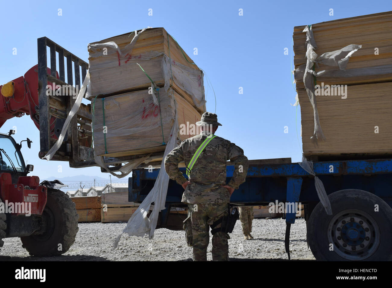 Petty Officer 1st Class (LS1) Franklin Stollings, noncommissioned officer for the Defense Logistics Agency-Distribution Services, ensures the alignment of wood being loaded onto a flatbed that was sold to an Afghan company for a white goods contract on Bagram Air Field, Afghanistan, July 27, 2014. White goods are excess Department of Defense property that is sold to local businesses. (DoD photo by U.S. Army Maj. Devon McRainey/Released) Defense Logistics Agency white goods sale 140727-A-XY287-003 Stock Photo