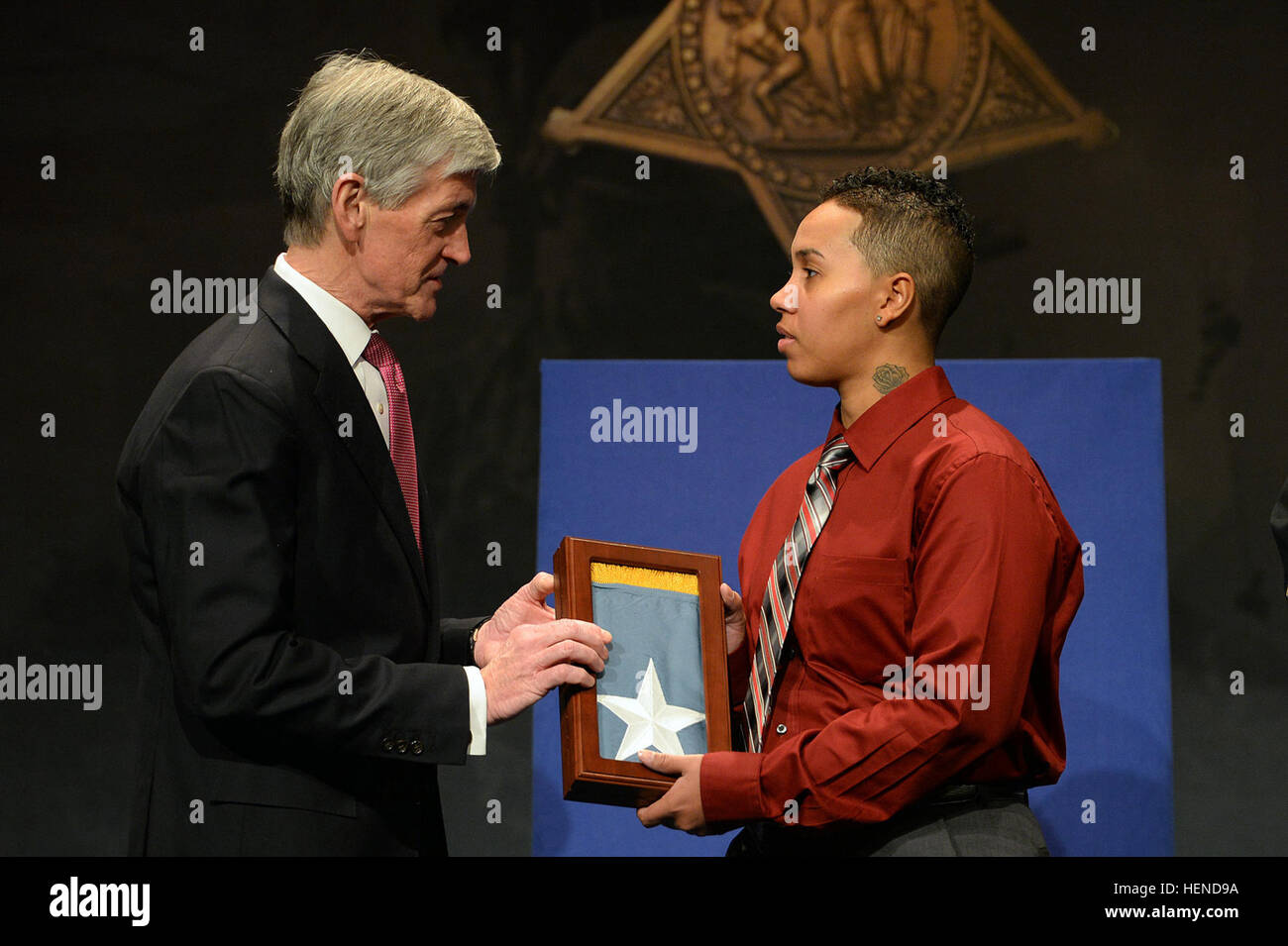 Secretary of Army John McHugh presents the Medal of Honor Flag to Sgt. Ashley Randall, on behalf of her grandfather Pvt. Demensio Rivera, one of 24 Army veterans honored during the Valor 24 Hall of Heroes Induction ceremony, held at the Pentagon, Washington D.C., March 19, 2014. (U.S. Army photo by Mr. Leroy Council/Released) Valor 24 Hall of Heroes ceremony, presentation for Demensio Rivera Stock Photo