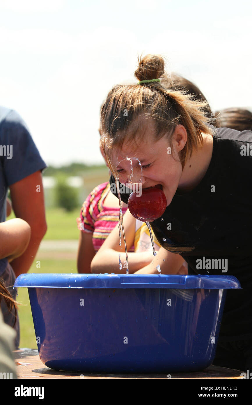 A Romanian girl visiting MK Air Base for an Independence Day celebration June 28 gets drenched while bobbing for an apple. The Black Sea Rotational Force at MK Air Base hosted about 400 local Romanians for the community holiday, mostly underprivileged youths from local placement centers. (U.S. Army photo by Sgt. Brandon Hubbard, 21st TSC Public Affairs, USAREUR) US military hosts 400 Romanian youths for Independence Day 140628-A-AU317-415 Stock Photo