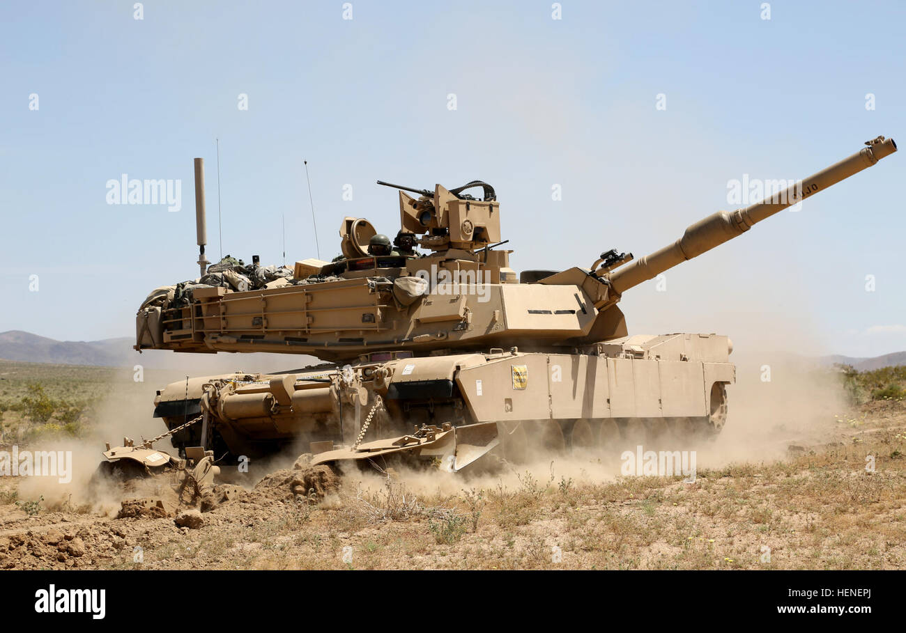 U.S. Army Soldiers from Charlie Company, 1st Brigade, 1st Infantry Division plow a path in a breach clearing Abrams Tank during Decisive Action Rotation 14-06 at the National Training Center on Fort Irwin, Ca., April 20, 2014.  At the NTC, decisive action exercises provide a comprehensive approach to training Brigade Combat Teams in a joint, interagency, intergovernmental and multinational environment.  (U.S. Army photo by Spc. Randis Monroe/Released) Clear the way 140420-A-XB890-027 Stock Photo