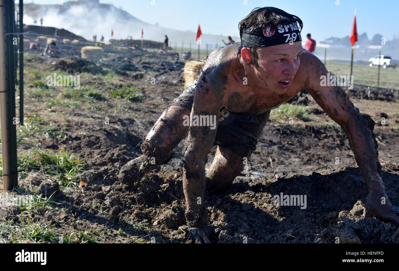 A Colorado Military Spartan Race competitor crawls under the barbwire