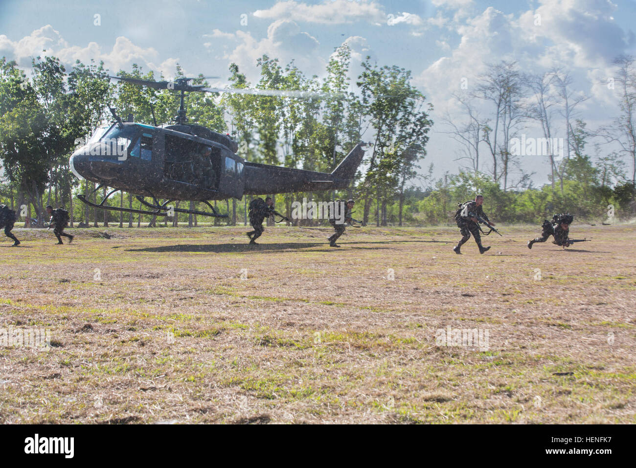 Armed Forces of the Philippines and U.S service members exit a helicopter during air assault training at Fort Magsaysay, Philippines, May 5, 2014. Philippine Soldiers of Charlie Company, 20th Infantry Battalion bound forward in squad elements to engage pop-up targets during Balikatan 2014. This year marks the 30th iteration of the exercise, which is an annual Republic of the Philippines-U.S. military bilateral training exercise and humanitarian civic assistance engagement. (U.S. Army Photo by Spc. Michael G. Herrero/Released) Air assault live fire exercise 140505-A-IR245-121 Stock Photo