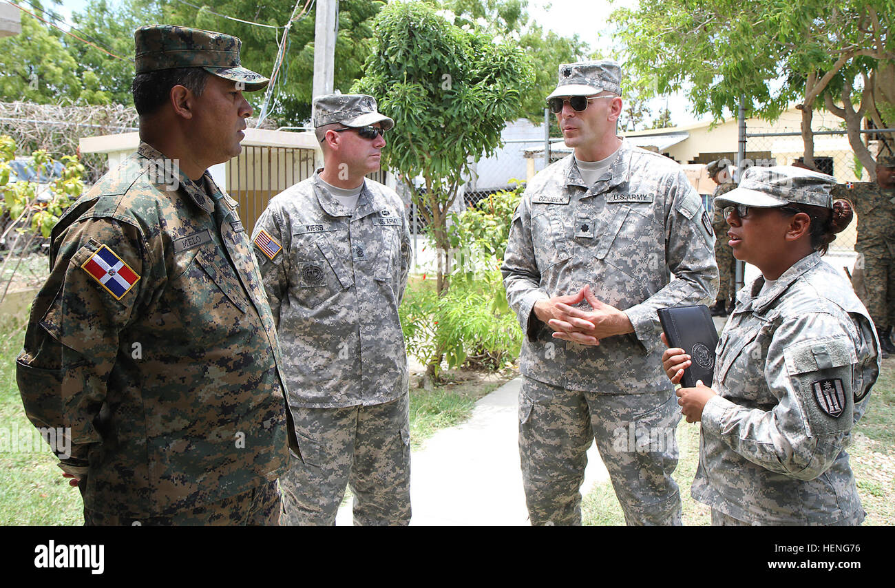 Task Force Larimar commander, Lt. Col. Christopher L. Dziubek (second from the right) discusses future plans for a medical clinic with Dominican Republic Army Col. Andres Santos Melo, commander of the 5th Infantry Brigade (far left) during the humanitarian and civic assistance mission, Beyond the Horizon 2014, May 13. The civil affairs team is providing information to local communities about BTH, a mission in which troops are building schools, clinics and also providing medical care to local citizens at no cost. (U.S. Army photo by Sgt. True Thao, 364th Press Camp Headquarters, Task Force Lari Stock Photo