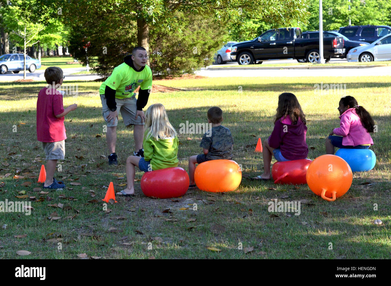 Pfc. Keegan Clark, volunteer, 108th Military Police Company, 503rd Military Police Battalion, 16th Military Police Brigade, prepares the children for their own race using hopper balls at the United Service Organizations' (USO) Run for the Troops 5k, May 17 at Methodist University. The race brought over 200 participants from the military and civilian community together for a common cause, to support the troops. The money raised from this event benefits the Fort Bragg and Fayetteville Regional Airport USO centers. (U.S. Army photo by Sgt. Amie J. McMillan, 10th Press Camp Headquarters) USO Run f Stock Photo