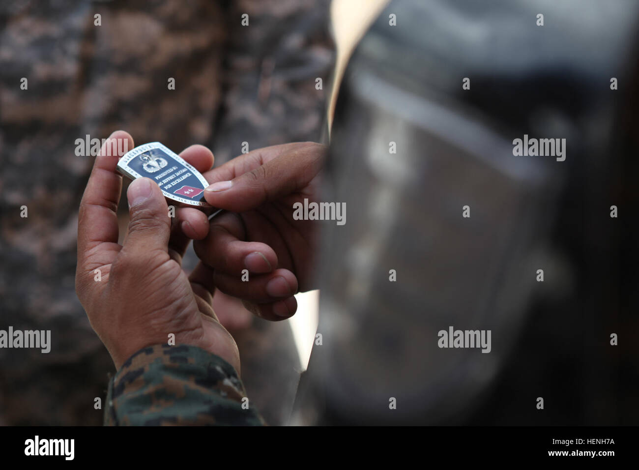 A U.S. Army Soldier with the 318th Psychological Operations Company, shows a Guatemalan Soldier a coin outside of a Medical Readiness Training Exercise, during Beyond the Horizon, San Jose, Guatemalan, May 25, 2014. Beyond the Horizon is an annual exercise that embraces the partnership between the United States and Guatemala, to provide focused humanitarian assistance through various medical, dental, and civic action programs. (U.S. Army photo by Spc. Richard Morales/released) Beyond the Horizon 2014, Guatemala 140525-A-EX861-010 Stock Photo