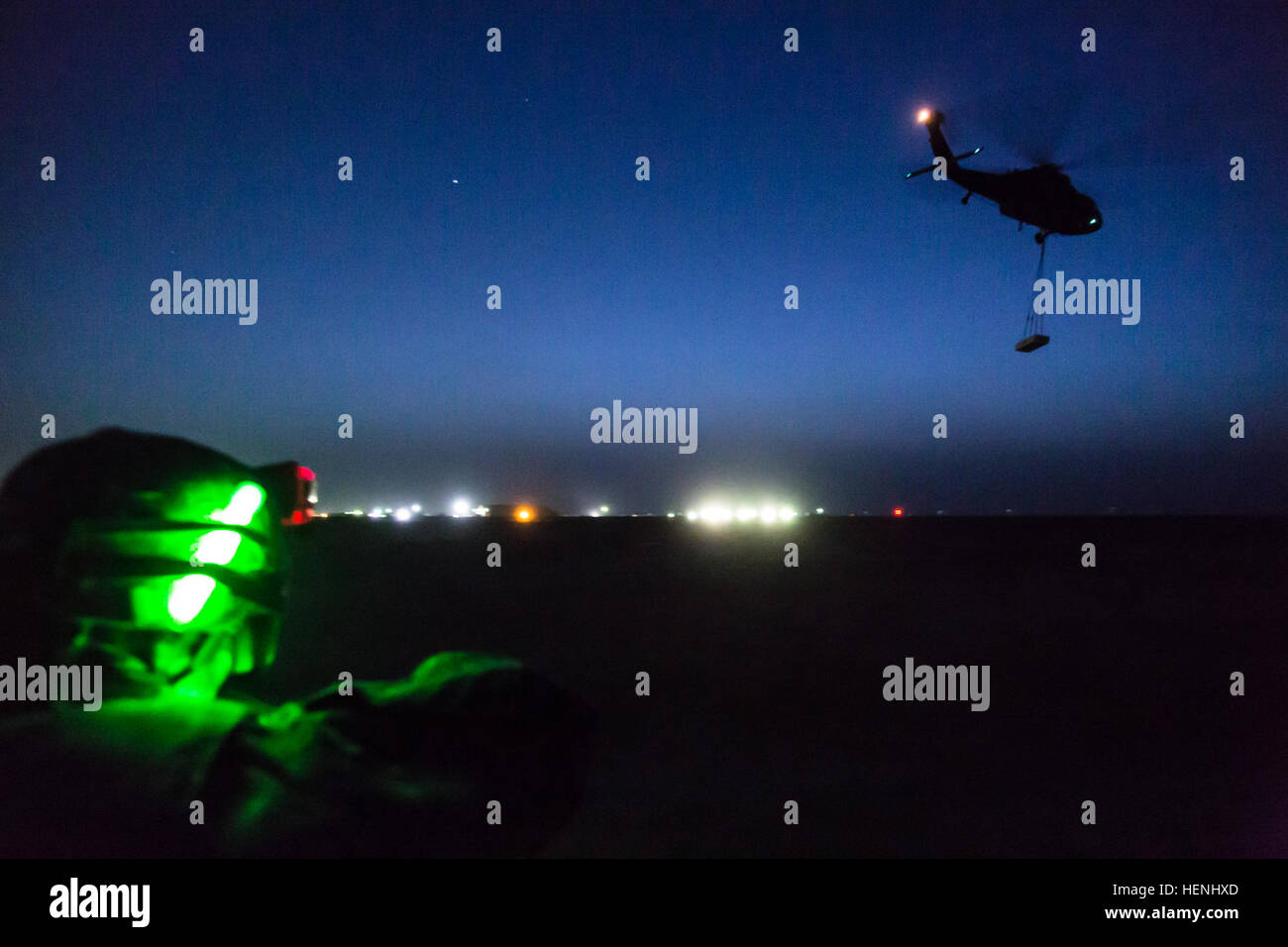 A UH-60 Black Hawk operated by Company A, 3rd Battalion, 142nd Assault Helicopter Battalion, flies off after picking up a 4,000 lb. weight during night sling load operations with the 642nd Aviation Support Battalion on June 5, 2014, in Camp Buehring, Kuwait. The 642nd and 142nd, both under the 42nd Combat Aviation Brigade, New York Army National Guard, are deployed to Kuwait in support of Operation Enduring Freedom. (N.Y. Army National Guard photo by Sgt. Harley Jelis/Released) 642nd Aviation Support Battalion night sling load 140605-A-AR422-106 Stock Photo