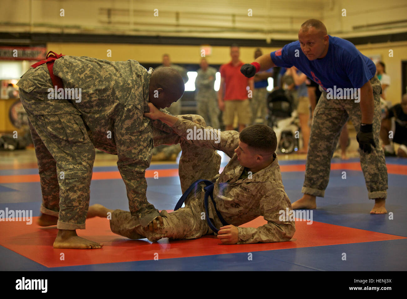 A U.S. Army Soldier and U.S. Marine fight head to head while being observed by a referee during an Army Combatives Tournament at Fort Dix, N.J., June 7, 2014. This tournament includes Soldiers, Airmen and Marines competing in different weight classes for a chance to win the title. (U.S. Army photo by Sgt. Austin Berner/Released) 98th Division Army Combatives Tournament 140607-A-BZ540-202 Stock Photo