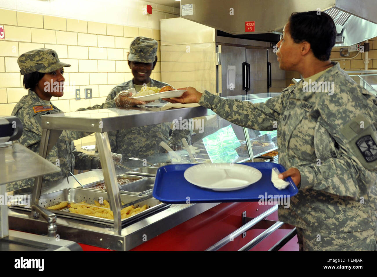 U.S. Army Spc. Coree Annis, left, and Sgt. Markeada Smith, center, both food service specialists with Task Force Wolf, serve Capt. Annette Williams, with Task Force Gold, during lunch service for Cadet Summer Training at Fort Knox, Ky., June 9, 2014.  (U.S. Army photo by Staff Sgt. Shejal Pulivarti/Released).... U.S. Army Spc. Coree Annis, left, and Sgt. Markeada Smith, center, both food service specialists with Task Force Wolf, serve Capt. Annette Williams, with Task Force Gold, during lunch service for Cadet Summer 140609-A-IO170-010 Stock Photo