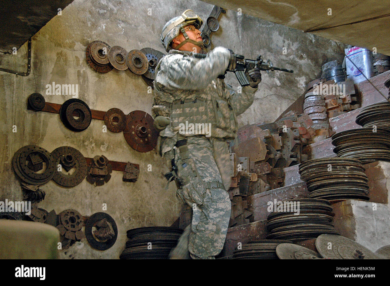 Spc. Damon GrayEagle, an infantryman in 1st Platoon, Company D, 1st Battalion, 8th Infantry Regiment from Fort Carson, Colo., moves up the stairs of an Iraqi mechanics shop, searching it for explosives or enemy activity during a clearing operation in Mosul, Iraq, April 1. Iraqi Army Division led raid on Mosul neighborhood finds car bomb factory 83281 Stock Photo