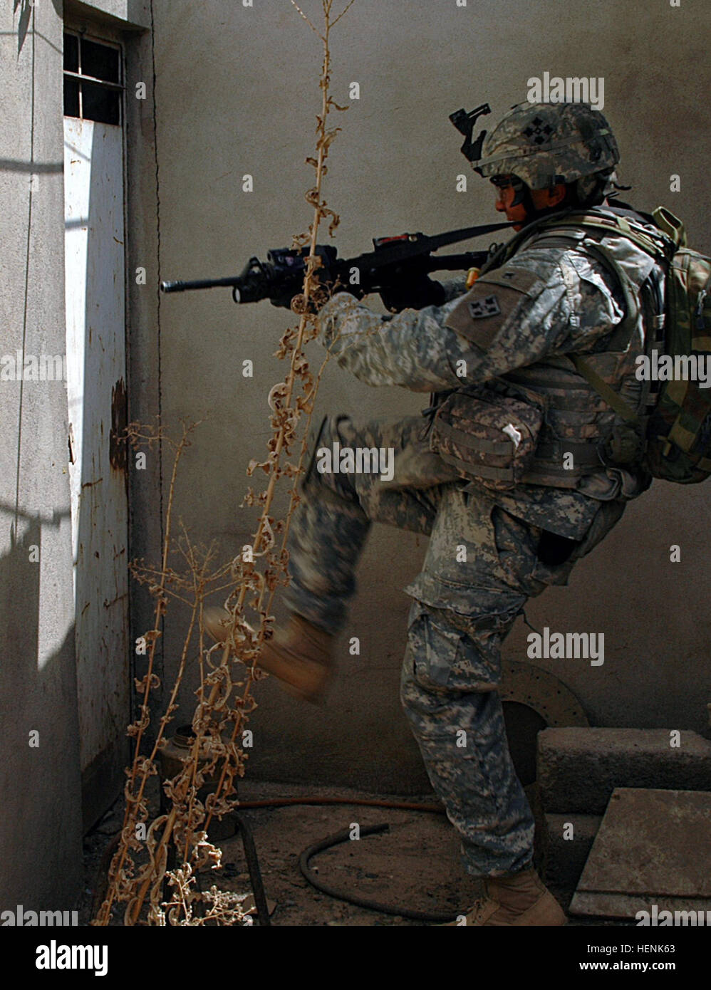 Spc. Mark Ramirez, an infantryman in 1st Platoon, Company D, 1st Battalion, 8th Infantry Regiment from Fort Carson, Colo., works to negotiate a locked door during a clearing operation in Mosul, Iraq, April 1. A car bomb factory, several bags of homemade explosives and bomb making materials were found and destroyed during the raid. Iraqi Army Division led raid on Mosul neighborhood finds car bomb factory 83282 Stock Photo