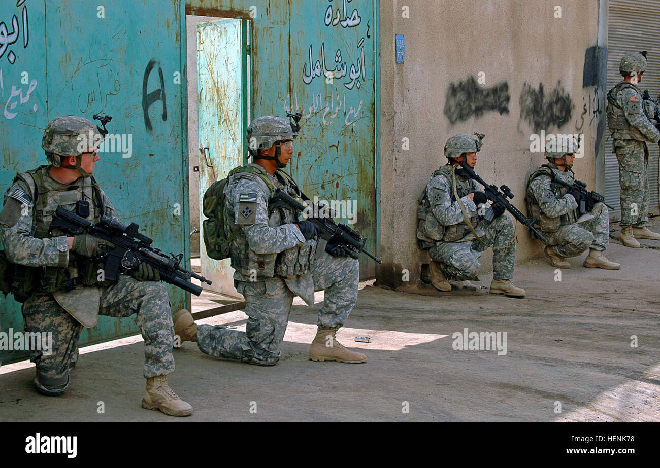 Soldiers of 1st Platoon, Company D, 1st Battalion, 8th Infantry Regiment from Fort Carson, Colo., take a knee and pull security during a clearing operation in Mosul, Iraq, April 1. The operation was planned and led by the Iraqi Army and wielded several bags of homemade explosives, a car bomb factory and bomb making materials. Iraqi Army Division led raid on Mosul neighborhood finds car bomb factory 83283 Stock Photo