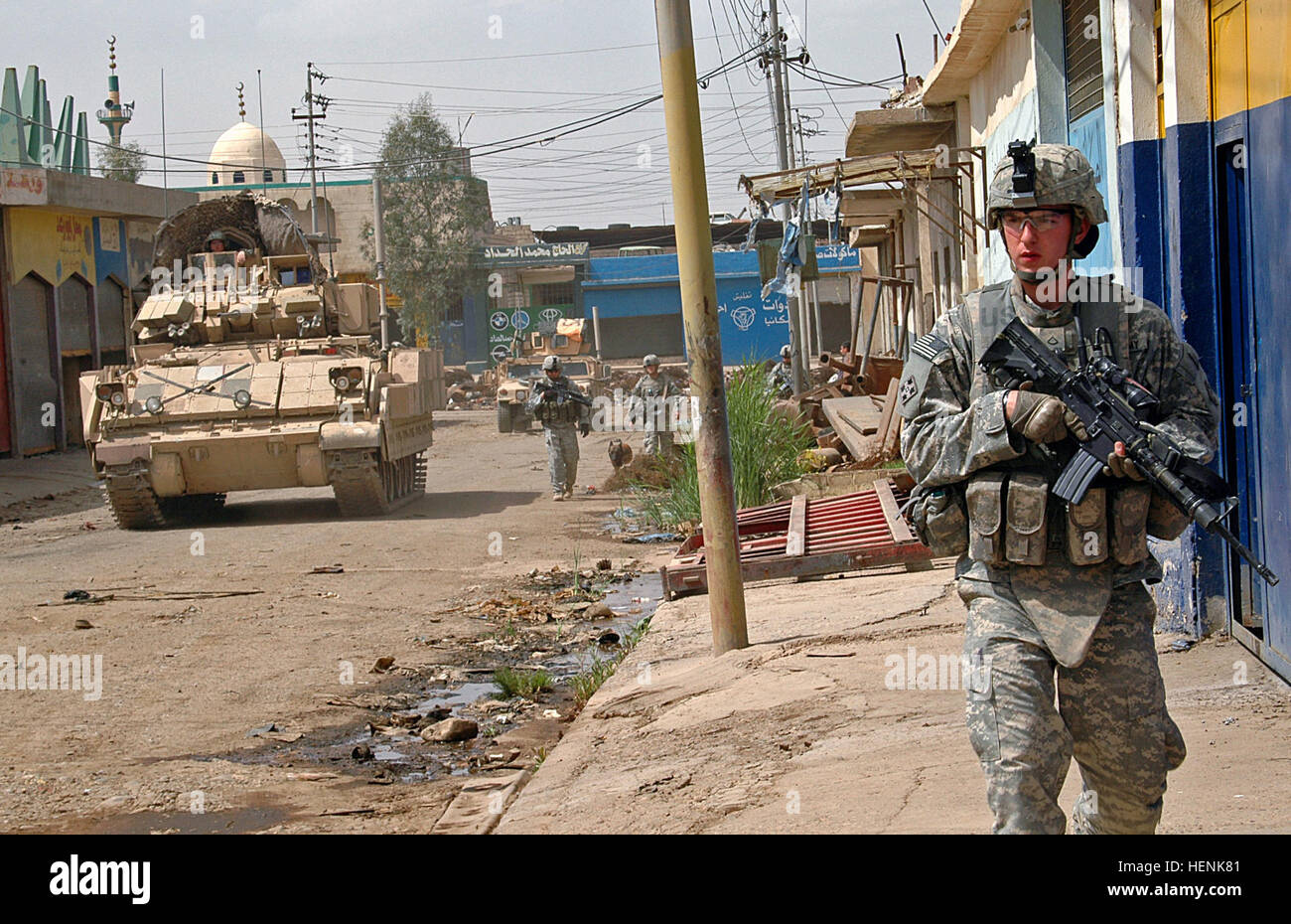 Pfc. Adam Devries, an infantry Soldier in 1st Platoon, Company D, 1st Battalion, 8th Infantry Regiment from Fort Carson, Colo., patrols the streets of Mosul, April 1, with members of his company under as a Bradley Armored Personnel Carrier moves along side providing security. Iraqi Army Division led raid on Mosul neighborhood finds car bomb factory 83278 Stock Photo
