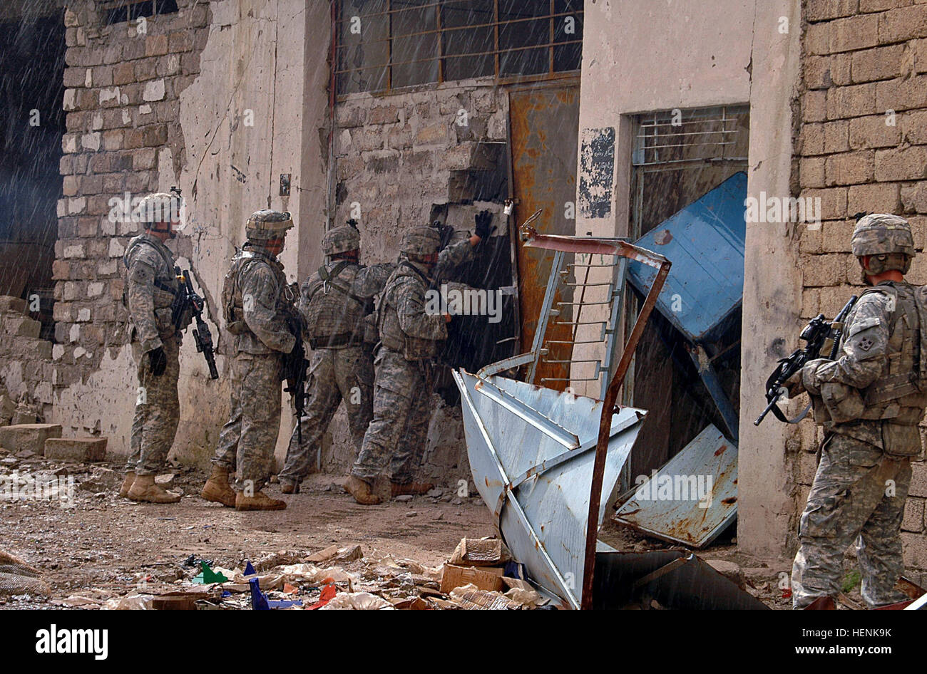 Infantry Soldiers of 1st Platoon, Company D, 1st Battalion, 8th Infantry Regiment from Fort Carson, Colo., raid a building in Mosul, Iraq during the rainy morning hours of April 1. Infantry Soldiers conduct Mosul raid through rain and shine 83272 Stock Photo