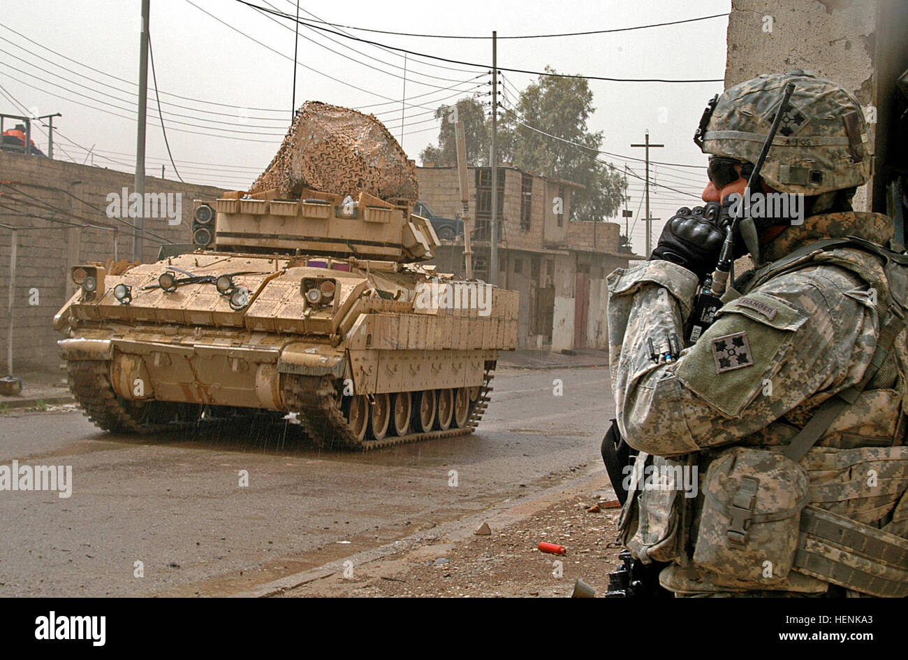 1st Lt. Donald Maloy, 1st Platoon leader, Co. D, 1st Battalion, 8th Infantry Regiment from Fort Carson, Colo., communicates through his radio while a Bradley Armored Personnel Carrier provides cord-on security during a joint Iraqi Army and coalition forces clearing operation in the al-Sinaa neighborhood of Mosul, April 1. Infantry Soldiers conduct Mosul raid through rain and shine 83269 Stock Photo