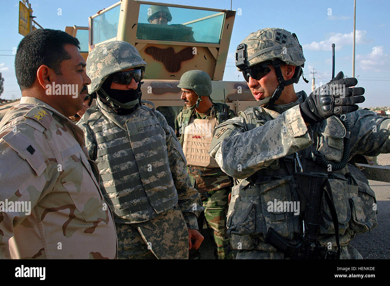 First Lt. Donald Maloy, 1st Platoon leader of Company D, 1st Battalion, 8th Infantry Regiment from Fort Carson, Colo., communicates his next move to Iraqi army Capt. Zatune Molood Hasaal, commander of 1st Company, 4th Battalion, 2nd Division during an IA led raid on a Mosul, Iraq, neighborhood April 1. Iraqi Army clears Mosul neighborhood after car bombs on combat outposts 83261 Stock Photo