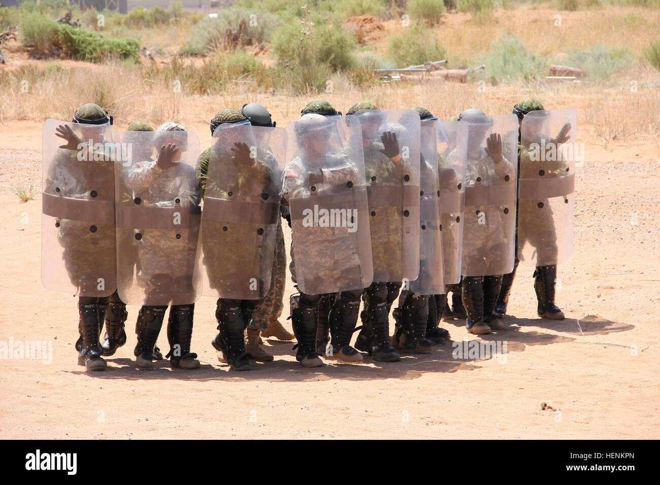 A mix of Canadian armed forces service members and U.S. Army Reserve Soldiers from the 744th Military Police Battalion, 11th MP Brigade, conduct riot control formations during Operation Guardian Justice at Forward Operating Base Westbrook in McGregor Range, N.M., June 26. Canada joins Guardian Justice 140626-A-DO208-003 Stock Photo