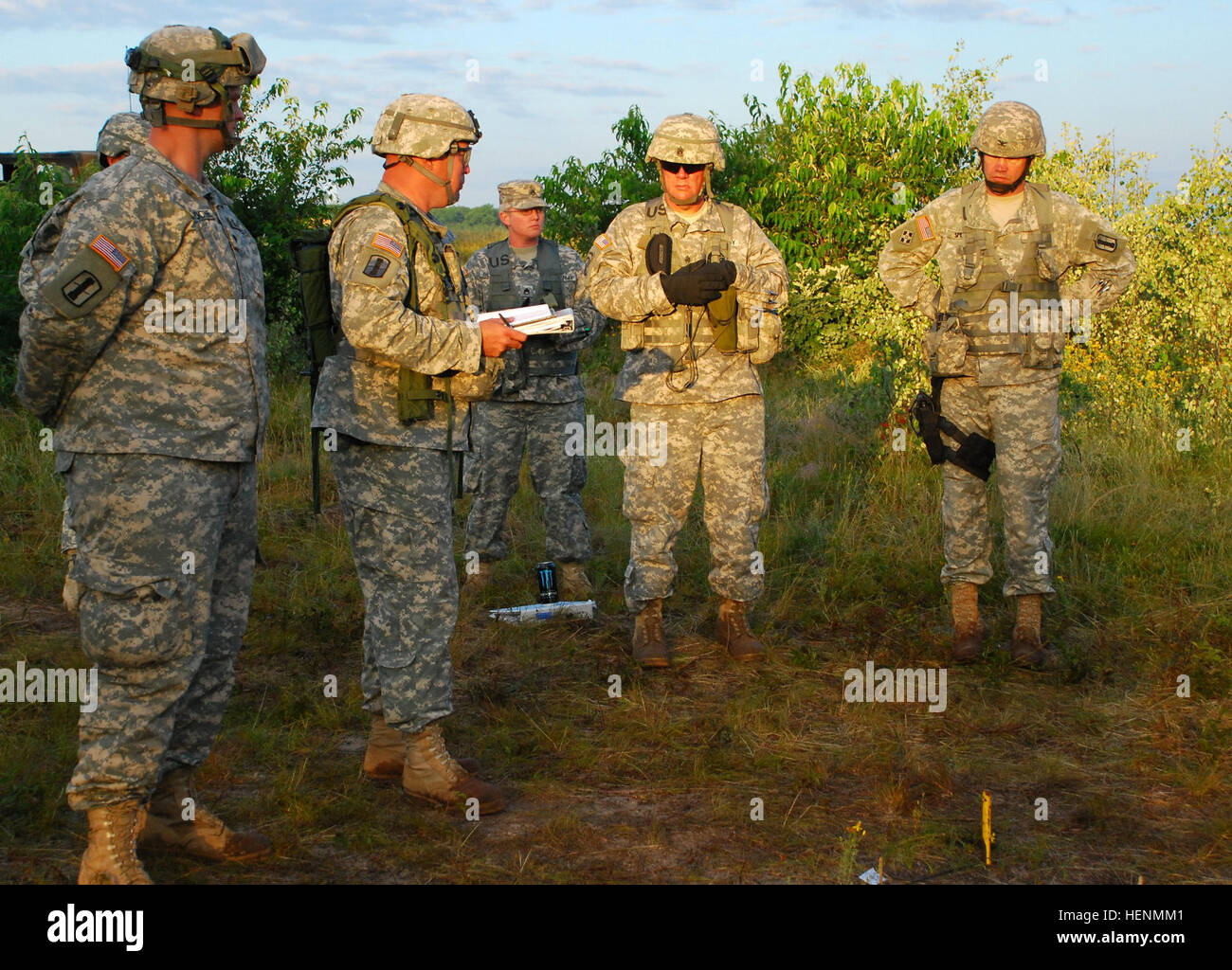 Col. Thomas Spencer, commander, 197th Field Artillery Brigade, and Command Sgt. Maj. Victor May, command sergeant major, 197th Field Artillery Brigade provide feedback to Capt. Delbert Avery, commander, Bravo Battery, 119th Field Artillery, and Spc. Jordan LaRoche, driver, Bravo Battery, 119th Field Artillery, during an After Action Review, at Camp Grayling Joint Maneuver Training Center, Mich., July 14. They partook in one of the reconnaissance lanes as one of the exercises at eXportable Combat Training Capability. XCTC is a battle-field simulation for National Guard units to measure their co Stock Photo