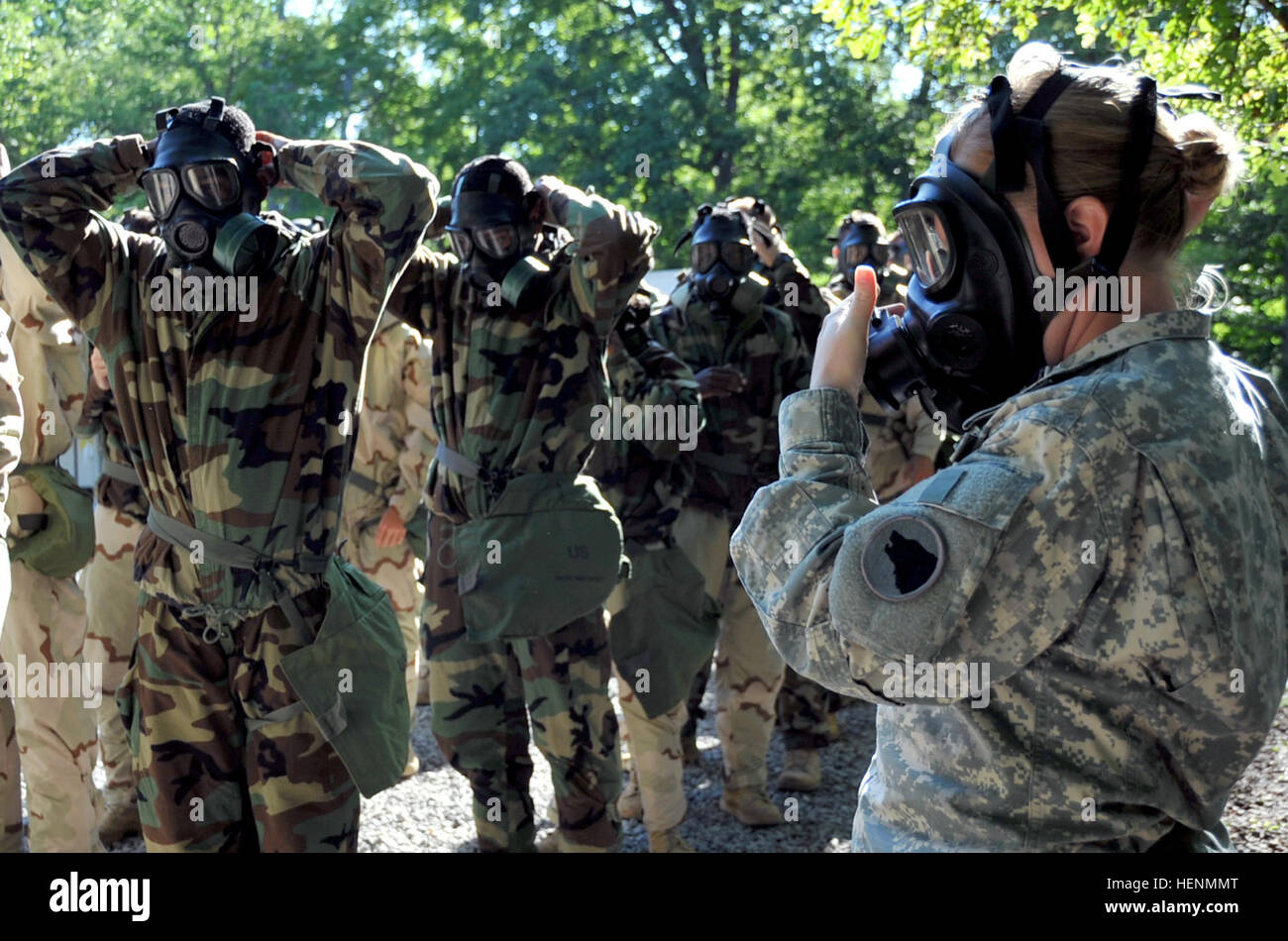 U.S. Army Spc. Katie Ray, platoon trainer, Chemical Biological Radiological Nuclear lane, Task Force Wolf, demonstrates the proper technique to don the gas mask during Cadet Summer Training (CST) on Fort Knox, Ky., July 15. The CBRN cadre, comprised of Reserve Soldiers from 2nd Battalion, 319th Regiment, 3rd Brigade, 104th Training Division, introduce cadets to the basics of CBRN. They teach them about all components of the protective gear and the proper procedures in reacting to a threat. (U.S. Army photo by Staff Sgt. Shejal Pulivarti/released) Cadre challenge cadets in chemical environment Stock Photo