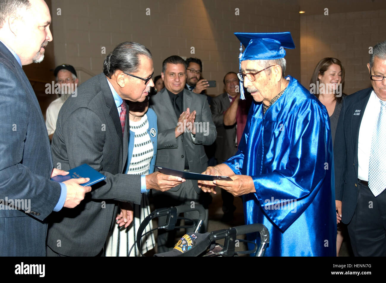 Ricardo Palacios receives his high school diploma at a graduation ceremony held at Bowie High School, El Paso, Texas, July 25, 2014. Ricardo, a WWII veteran, was a member of Company E, 2nd Battalion, 141st Infantry Regiment of the 36th Texas Division, 5th  Army. (U.S. Army photo by Sgt. Jarred Woods, 16th Mobile Public Affairs Detachment) WWII veterans receive long awaited honor 140725-A-ZA744-028 Stock Photo