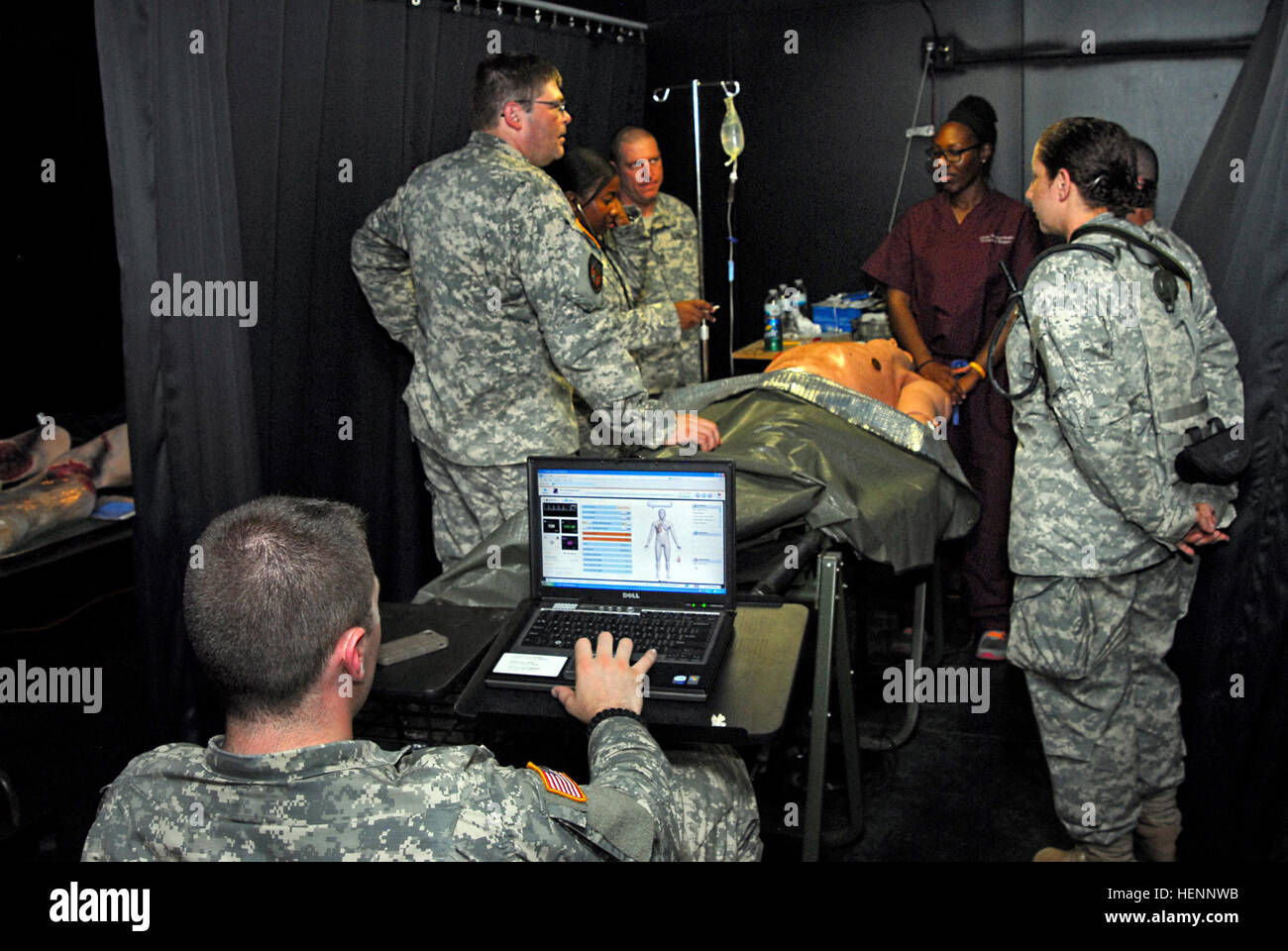 Soldiers assigned to Medical Command, New York Army National Guard, gather around Dr. Erica Igbindghene, an emergency room physician from Albany Medical Center, as she outlines the  procedure for tracheal intubation, a medical term for insertion of a tube into an external or internal orifice of the body for the purpose of adding or removing fluids during training at Camp Smith Training Site, Cortlandt Manor, N.Y., on Aug. 5, 2014. Igbindghene was invited to attend a day of training with the New York Army National Guard medics during their annual training to help them  improve this skill. As sh Stock Photo