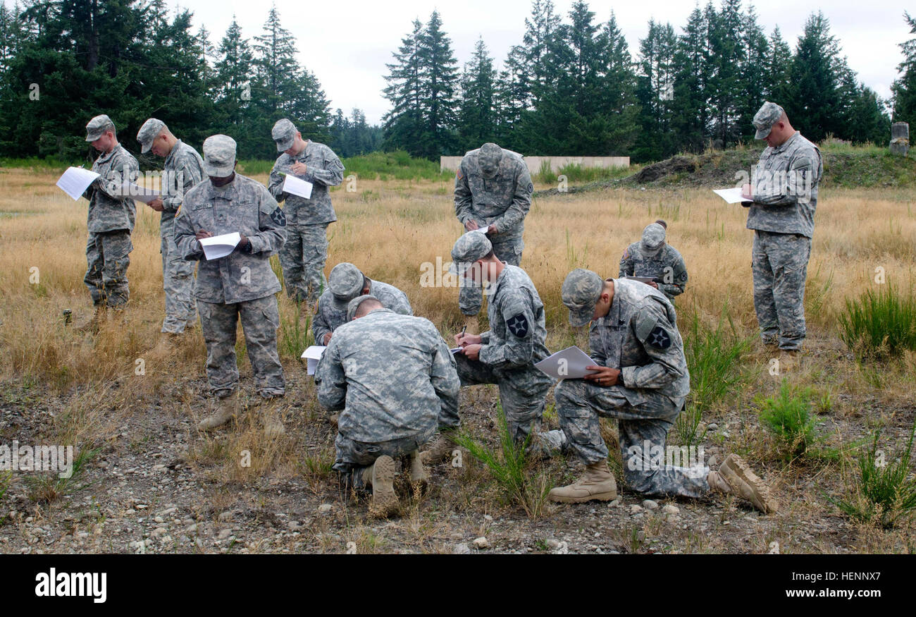 Soldiers from 2nd Stryker Brigade Combat Team, 2nd Infantry Division, 3rd Stryker Brigade Combat, 2nd ID, and 42nd Military Police Brigade, 593rd Sustainment Brigade, fill out participation forms prior to getting engaged by the Active Denial System at Joint Base Lewis-McChord, Wash. Aug. 6. The ADS projects a 1.5-meter beam of millimeter waves, which induce a temporary and reversible heating sensation to the target's skin. (U.S. Army photo by Sgt. Ryan Hallock) Active Denial System heats up JBLM Soldiers 140806-A-TG995-013 Stock Photo