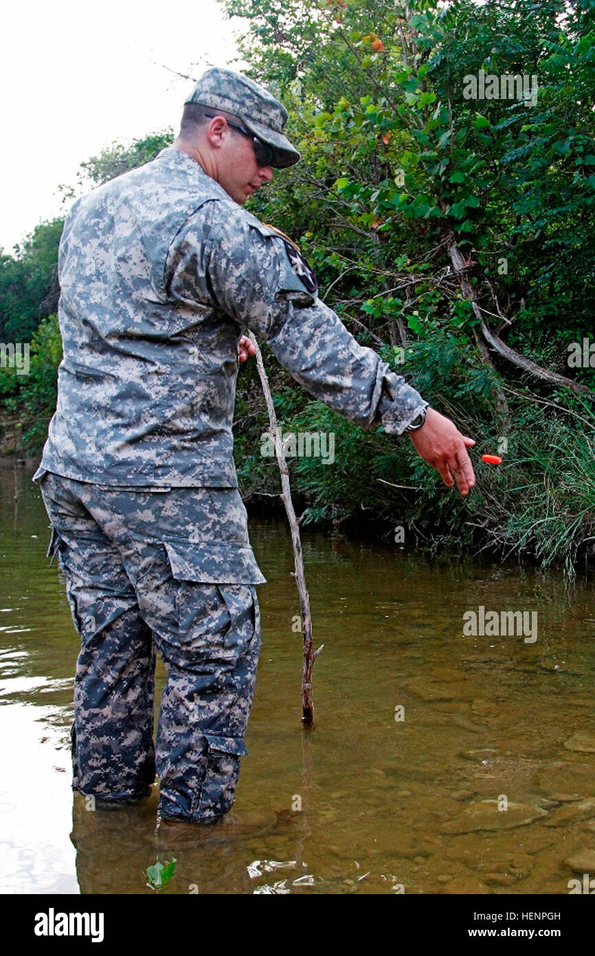 Spc. Zachary Adkins, a Boscobel, Wisconsin, native and combat engineer assigned to Headquarters and Headquarters Company 'Hammer,' 1st Brigade Combat Team 'Ironhorse,' 1st Cavalry Division, drops a Styrofoam fishing float  into a stream while measuring its velocity during First Team Training Aug. 21 at Fort Hood, Texas. Adkins learned this aspect of his military occupational specialty in preparation for the upcoming multinational training exercise, Combined Resolve III. (U.S. Army photo by Spc. Paige Behringer, 1BCT PAO, 1st Cav. Div.) Soldiers train, build teams, conduct counseling for First  Stock Photo