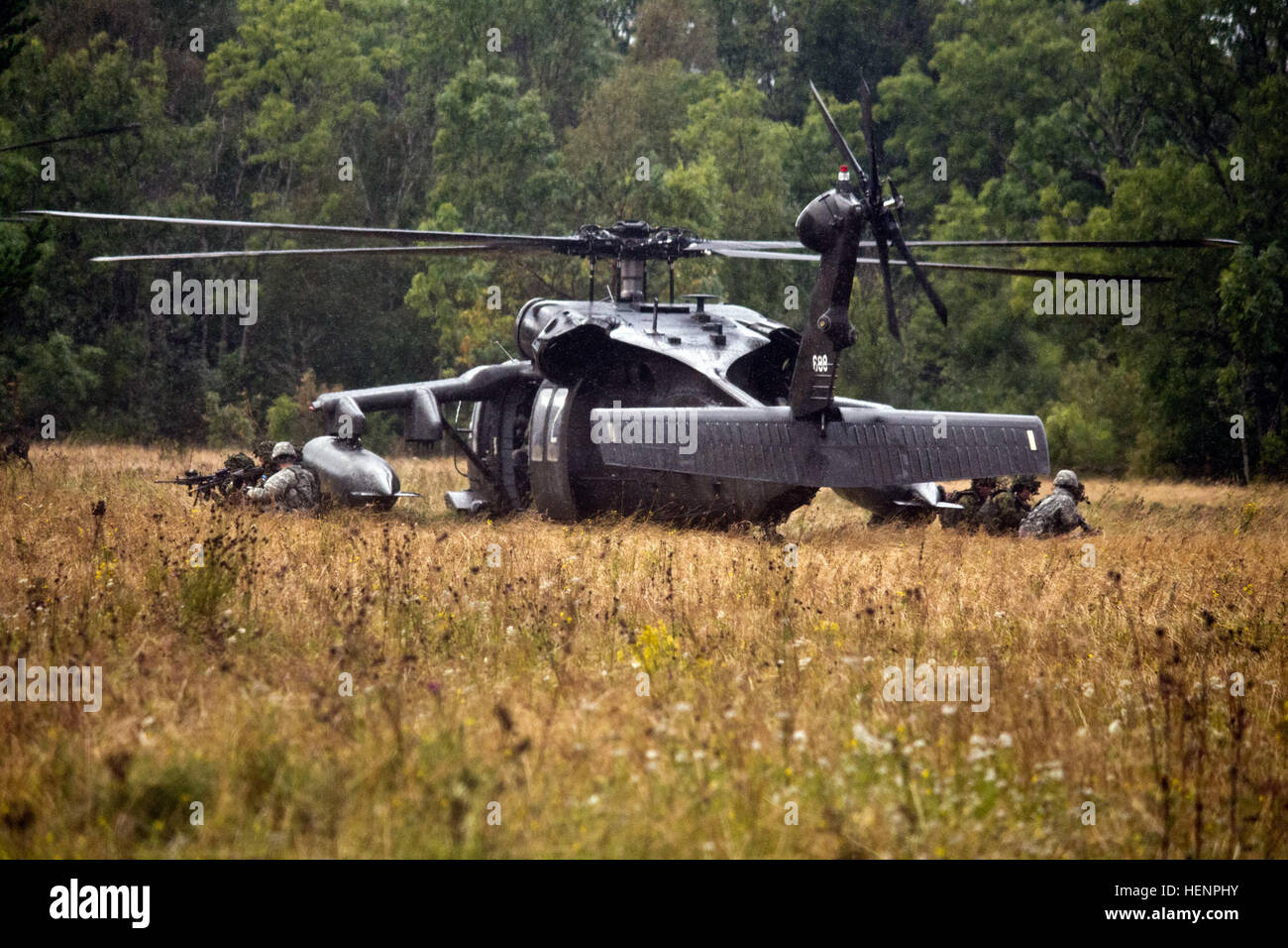 American paratroopers and Estonian soldiers exit a UH-60 Black Hawk Helicopter from the 12th Combat Aviation Brigade during an air assault training mission held Aug 22-24 in Paldiski, Estonia. The three-day exercise featured troops from Company B, 2nd Battalion, 503rd Infantry Regiment, 173rd Airborne Brigade and the Estonian Defense Forces’ Single Scouts Infantry Battalion executing day and night assaults. The training is part of Operation Atlantic Resolve, an exercise dedicated to demonstrating commitment to NATO obligations and maintaining interoperability with allied forces. Heroes on helo Stock Photo