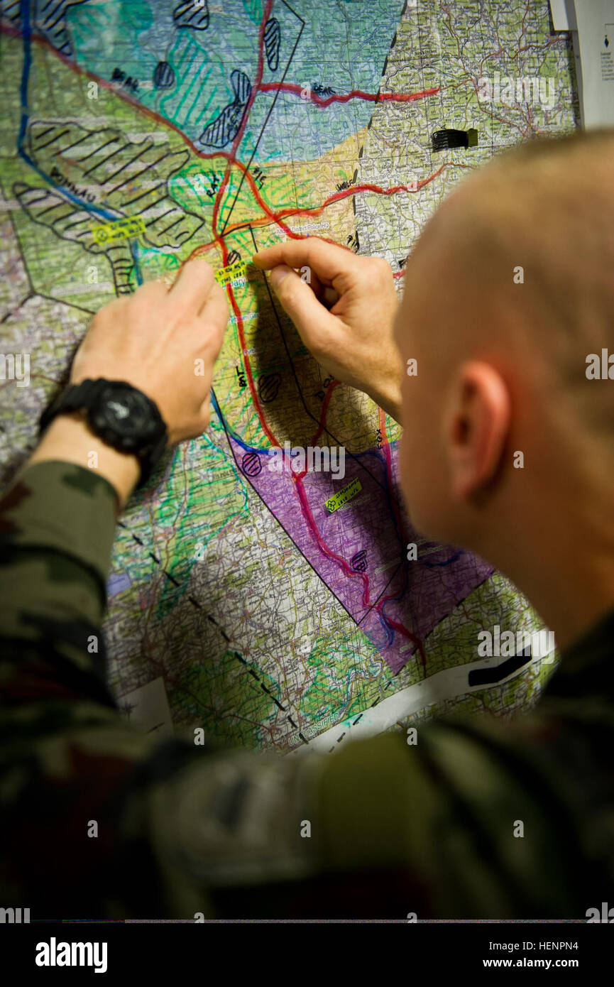 A Slovenian soldier plots troop movements on a simulated regional crisis map inside a tactical operations center in Postojna, Slovenia, Aug. 25, 2014, during Immediate Response 14. Immediate Response is a U.S. Army Europe-led combined joint tactical field training exercise designed to build interoperability between NATO, Croatia and its regional partner nations. (U.S. Army photo by Staff Sgt. Caleb Barrieau/Released) A Slovenian soldier plots troop movements on a simulated regional crisis map inside a tactical operations center in Postojna, Slovenia, Aug. 25, 2014, during Immediate Response 14 Stock Photo
