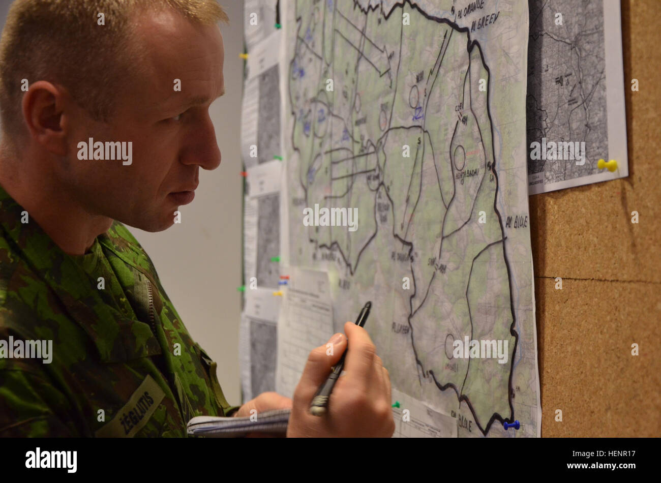 Lithuanian Land Force Staff Sgt. Albiwas Zeglaitis of 'Iron Wolf' Mechanized Infantry Brigade outline locations for training on a map during training exercise Saber Junction 2014 at the Joint Multinational Readiness Center in Hohenfels, Germany, Aug. 29, 2014. Saber Junction 2014 prepares U.S., NATO allies, and European security partners to conduct unified land operations through the simultaneous combination of offensive, defensive, and stability operations appropriate to the mission and the environment.  More information about Saber Junction 2014 can be found at http://www.eur.army.mil/SaberJ Stock Photo