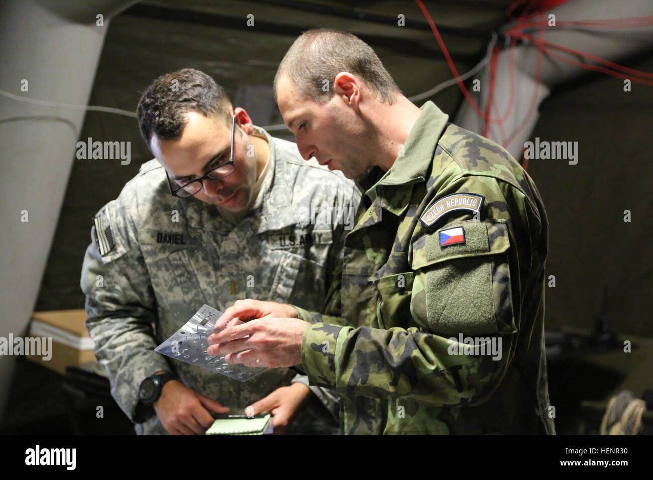 A U.S. Soldier of 1st Squadron (Airborne), 91st Cavalry Regiment, 173rd Airborne Brigade, left, and a Czech soldier of 1st Fire Battery, 131st Artillery Battalion, right, discusses map symbols during training exercise Saber Junction 2014 at the Joint Multinational Readiness Center in Hohenfels, Germany, Aug. 31, 2014. Saber Junction 2014 prepares U.S., NATO allies and European security partners to conduct unified land operations through the simultaneous combination of offensive, defensive and stability operations appropriate to the mission and the environment. More information about Saber Junc Stock Photo