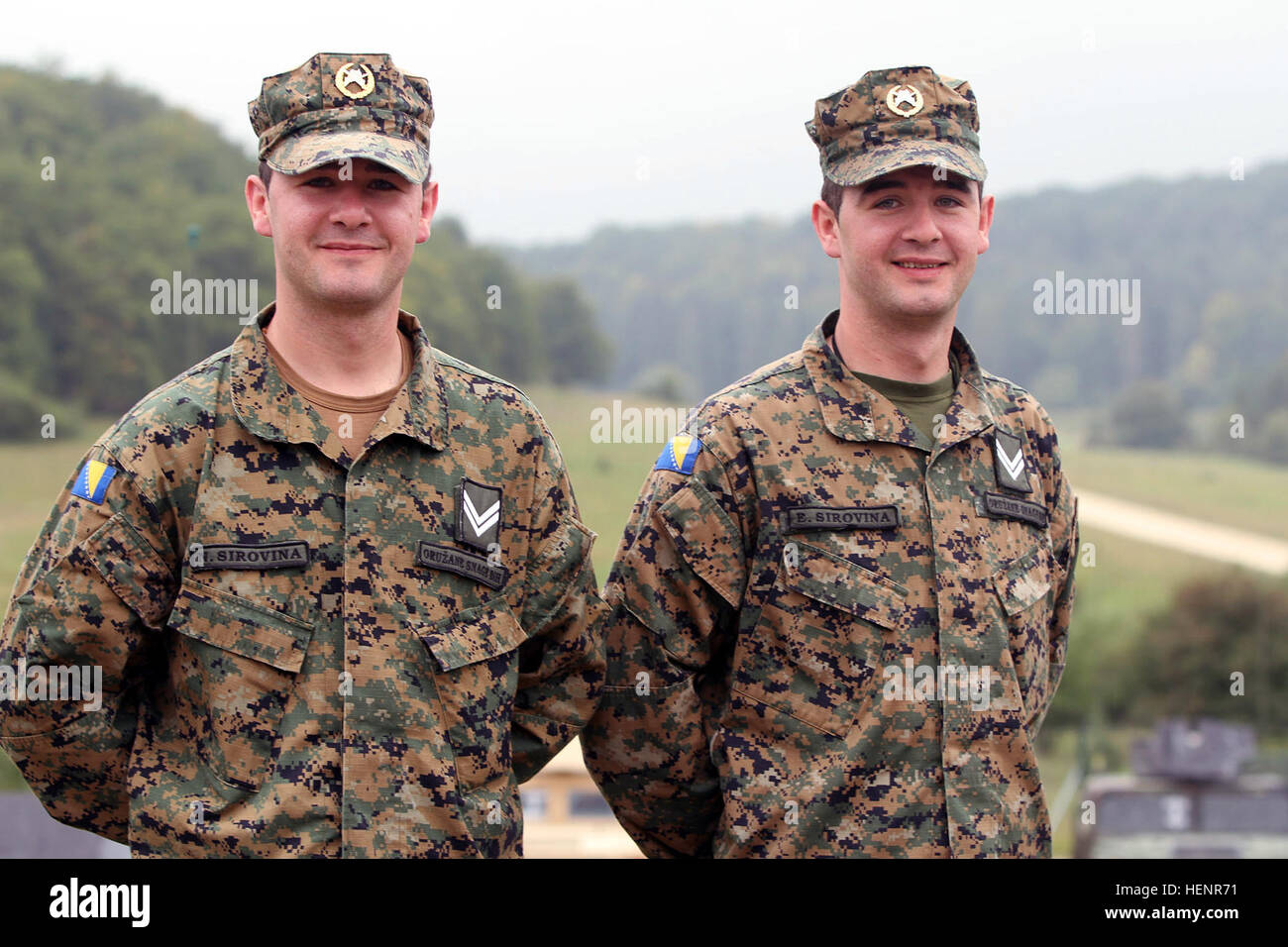 Twin Bosnian soldiers, both military police officers, pose for a photo during Saber Junction 2014 at the Hohenfels Training Area in Hohenfels, Germany, Sept. 2, 2014. The brothers have served together for six years. Saber Junction is a U.S. Army Europe-led exercise designed to prepare U.S., NATO and international partner forces for unified land operations. (U.S. Army photo by Sgt. Christina M. Dion/Released) Twin Bosnian soldiers, both military police officers, pose for a photo during Saber Junction 2014 at the Hohenfels Training Area in Hohenfels, Germany, Sept 140902-A-ZG808-129 Stock Photo