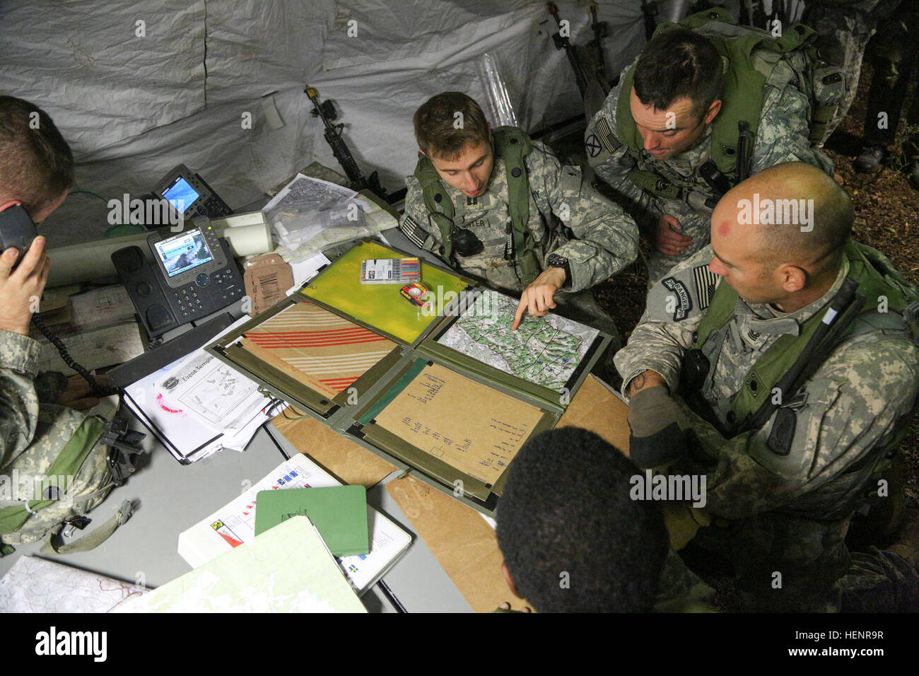 U.S. Soldiers with the 173rd Airborne Brigade Combat Team review a map in the tactical operations center Sept. 3, 2014, at the Joint Multinational Readiness Center in Hohenfels, Germany, during exercise Saber Junction 2014. Saber Junction is a U.S. Army Europe-led exercise designed to prepare U.S., NATO and international partner forces for unified land operations. (U.S. Army photo by Spc. Tyler Kingsbury/Released) U.S. Soldiers with the 173rd Airborne Brigade Combat Team review a map in the tactical operations center Sept 140903-A-LO967-001 Stock Photo