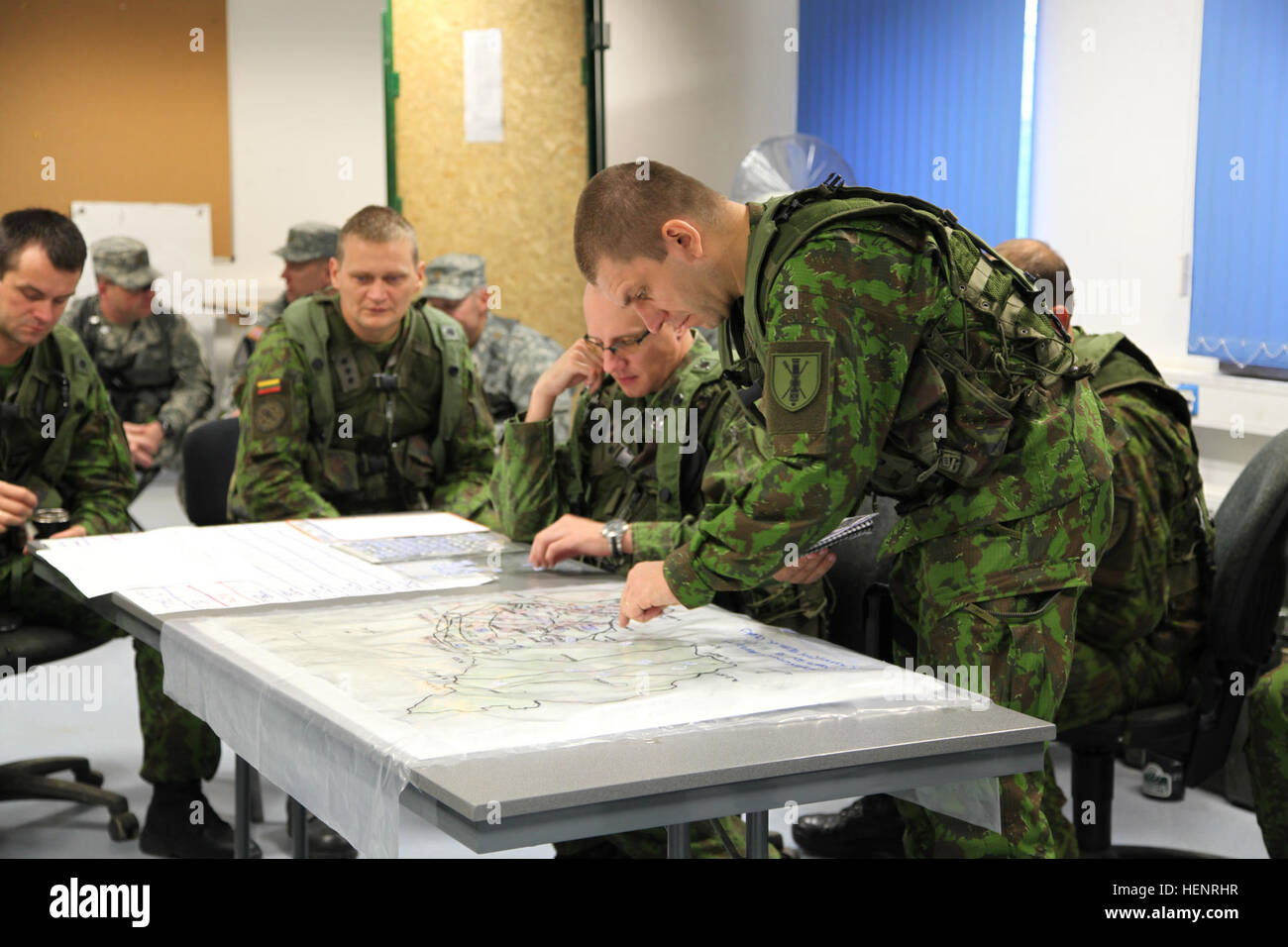 A Lithuanian soldier of 'Iron Wolf' Mechanized Infantry Brigade references a map while working to plan a mission during training exercise Saber Junction 2014 at the Joint Multinational Readiness Center in Hohenfels, Germany, Sept. 6, 2014. Saber Junction 2014 prepares U.S., NATO allies and European security partners to conduct unified land operations through the simultaneous combination of offensive, defensive and stability operations appropriate to the mission and the environment.  More information about Saber Junction 2014 can be found at http://www.eur.army.mil/SaberJunction/ (U.S. Army pho Stock Photo