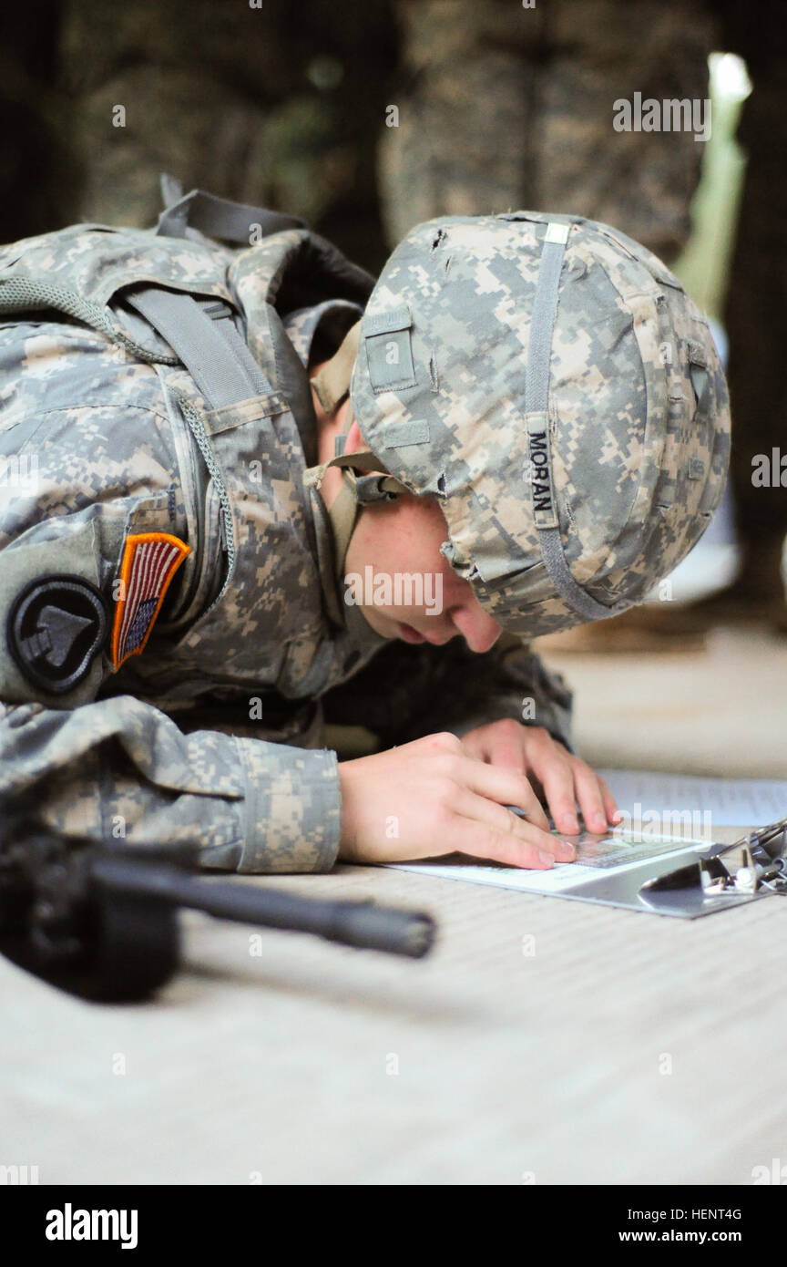 U.S. Army Spc. Brody Moran, assigned to A Company, 24th Military Intelligence Battalion, 66th Military Intelligence Brigade,  plots coordinates on a map during the land navigation portion of the  European Best Warrior Competition in Grafenwoehr, Germany, Sept. 14, 2014. The competition is a weeklong event that pushes Soldiers to the limits of their physical stamina, bearing, knowledge, adaptability and technical and tactical skills. The best warriors are ready and resilient Soldiers who live the Army values and lead from the front. (U.S. Army photo by Staff Sgt. Pablo N. Piedra/Released) Europ Stock Photo