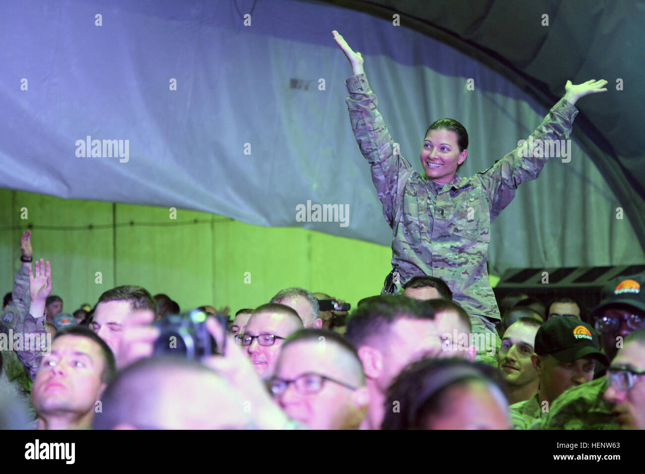 U.S. Army Soldier from the 160th Signal Brigade makes herself seen to get a Today Show Cap thrown to her during The Today USO Comedy Tour Show held at Bagram Air Field, Afghanistan, Oct. 1, 2014. The show was brought together by Al Roker and is meant to raise money for the United Services Organization (USO) so they can better support the service members deployed overseas. (U.S. Army photo by Staff Sgt. Daniel Luksan/ Released) The Today USO Comedy Tour 141001-A-QR427-209 Stock Photo