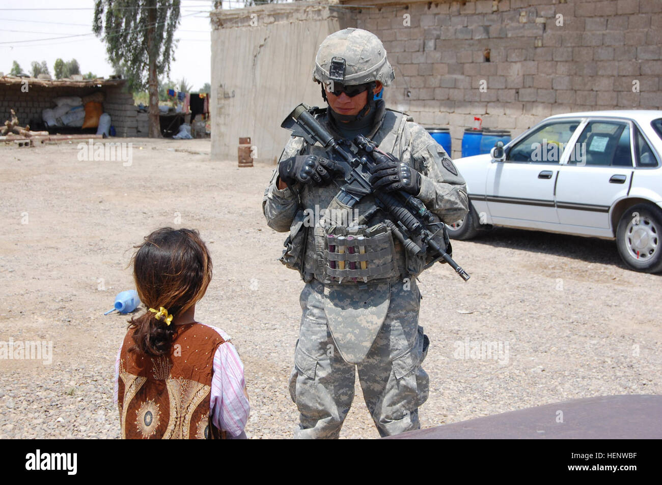 Spc. Austin Sandoval, a Lukachukai, Ariz., native, talks with an Iraqi girl while on patrol the East Anbar province, northwest of Baghdad, May 11. Sandoval is a mortarman assigned to Headquarters and Headquarters Company, 1st Battalion, 27th Infantry Regiment "Wolfhounds," 2nd Stryker Brigade Combat Team "Warrior," 25th Infantry Division, Multi-National Division - Baghdad. (U.S. Army photo/Staff Sgt. J.B. Jaso III) Securing safe place for Iraq's future 88834 Stock Photo