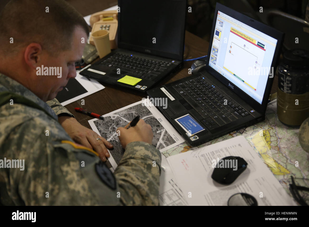 A U.S. Soldier with Alpha Troop, 1st Squadron (Airborne), 40th Cavalry Regiment plots points on a map while conducting tactical operations center operations during the Kosovo Force (KFOR) 19 Mission Rehearsal Exercise (MRE) Oct. 7, 2014, at the Joint Multinational Readiness Center in Hohenfels, Germany. The KFOR 19 MRE was designed to prepare the U.S. Army's 4th Infantry Brigade Combat Team (Airborne), 25th Infantry Division and multinational forces for operations in support of NATO in Kosovo. (U.S. Army photo by Spc. Brian Chaney/Released) KFOR 19 MRE 141007-A-EM978-005 Stock Photo