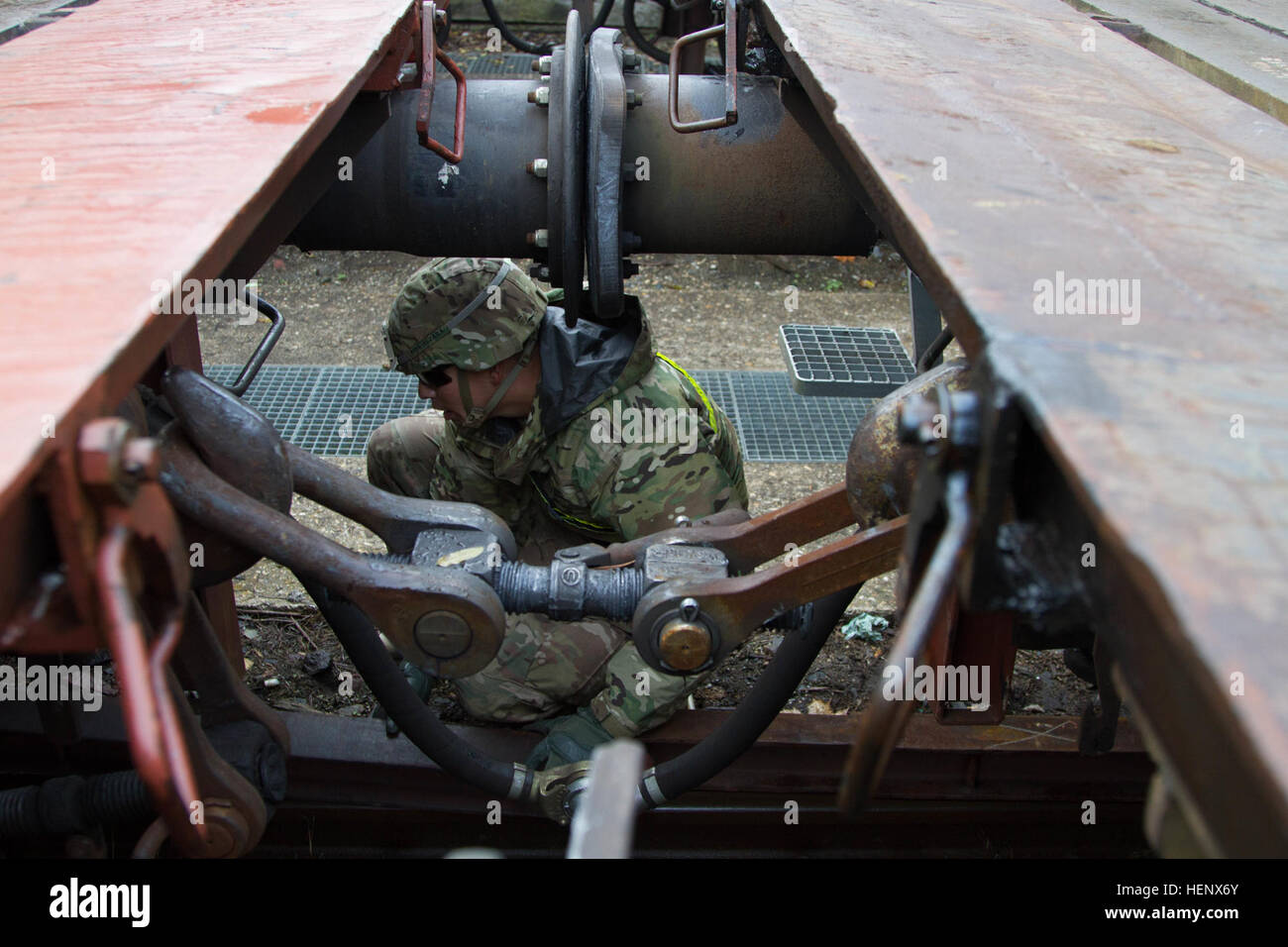 A Soldier from 1st Armored Brigade Combat Team, 1st Cavalry Division begins the unloading process by placing steel beams under the railcar to keep it stable when the M1A2 Abrams Tanks disembark in Hoensfells, Germany, Oct. 18. Soldiers from 1st ABCT, 1st Cavalry Division will train with NATO allies for the next several weeks to reassure them of our commitment to the NATO alliance (U.S. Army photo taken by Sgt. Alexander Skripnichuk, 7th Mobile Public Affairs Detachment) Railhead 141018-A-DU810-045 Stock Photo