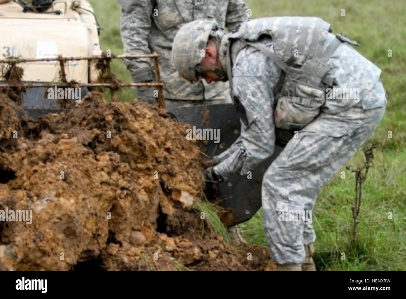 1st Lt. Michael Kukesh, the executive officer for Company A, 91st Engineer Battalion, 1st Brigade Combat Team, 1st Cavalry Division, removes dirt from an Assault Breaching Vehicle after overcoming several obstacles in a training exercise Oct. 29, 2014, in Hohenfels, Germany during Combined Resolve III. Combined Resolve III is a multinational training exercise designed to reinforce our nation’s commitment to ally and partner nations. (U.S. Army photo by Spc. Marcus Floyd, 7th Mobile Public Affairs Detachment) Cleaning the Plow 141029-A-JI163-908 Stock Photo